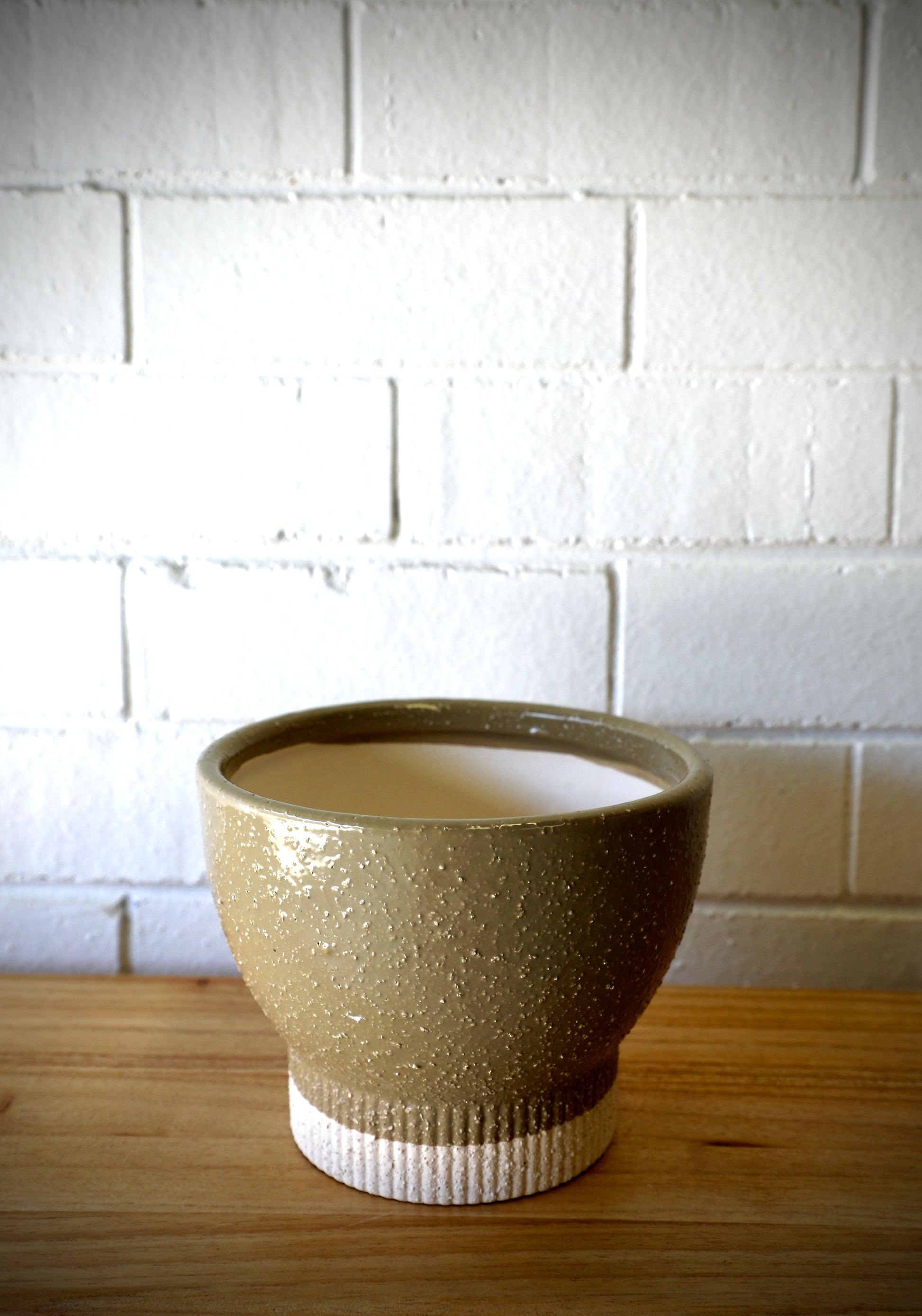 The Romulus Ceramic Pot - Large, 18 X 14, features a cylindrical bottom that tapers out in a bowl shape.  Colours, Olive and cream. Measures 18 Diameter X 14 Height. Plain