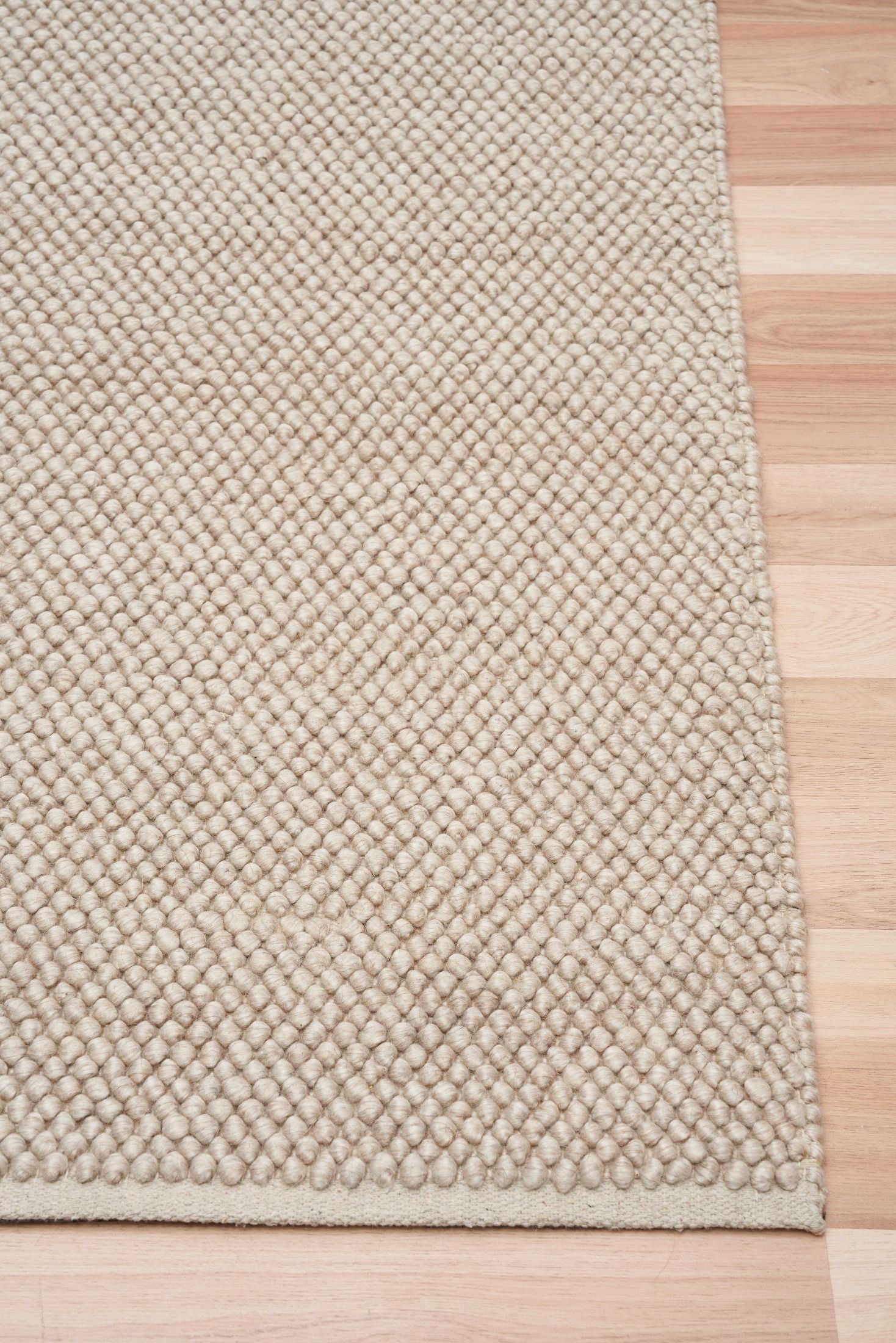 Rusta Beige hand-woven wool rug featuring a looped pile textured design in soft neutral beige tones, ideal for modern and contemporary interiors. Sizes 155 X 225, 200 X 290, 240 X 320 and 300 X 400. Corner.