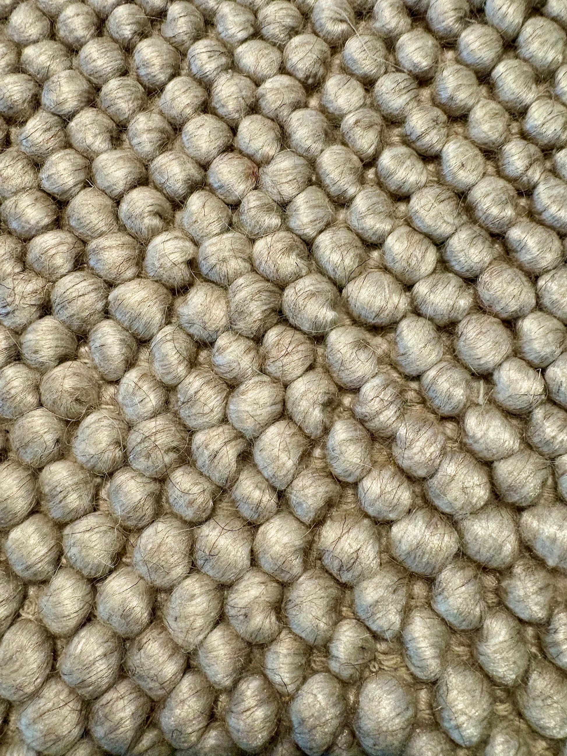 Rusta Beige hand-woven wool rug featuring a looped pile textured design in soft neutral beige tones, ideal for modern and contemporary interiors. Sizes 155 X 225, 200 X 290, 240 X 320 and 300 X 400. Fibres Close.