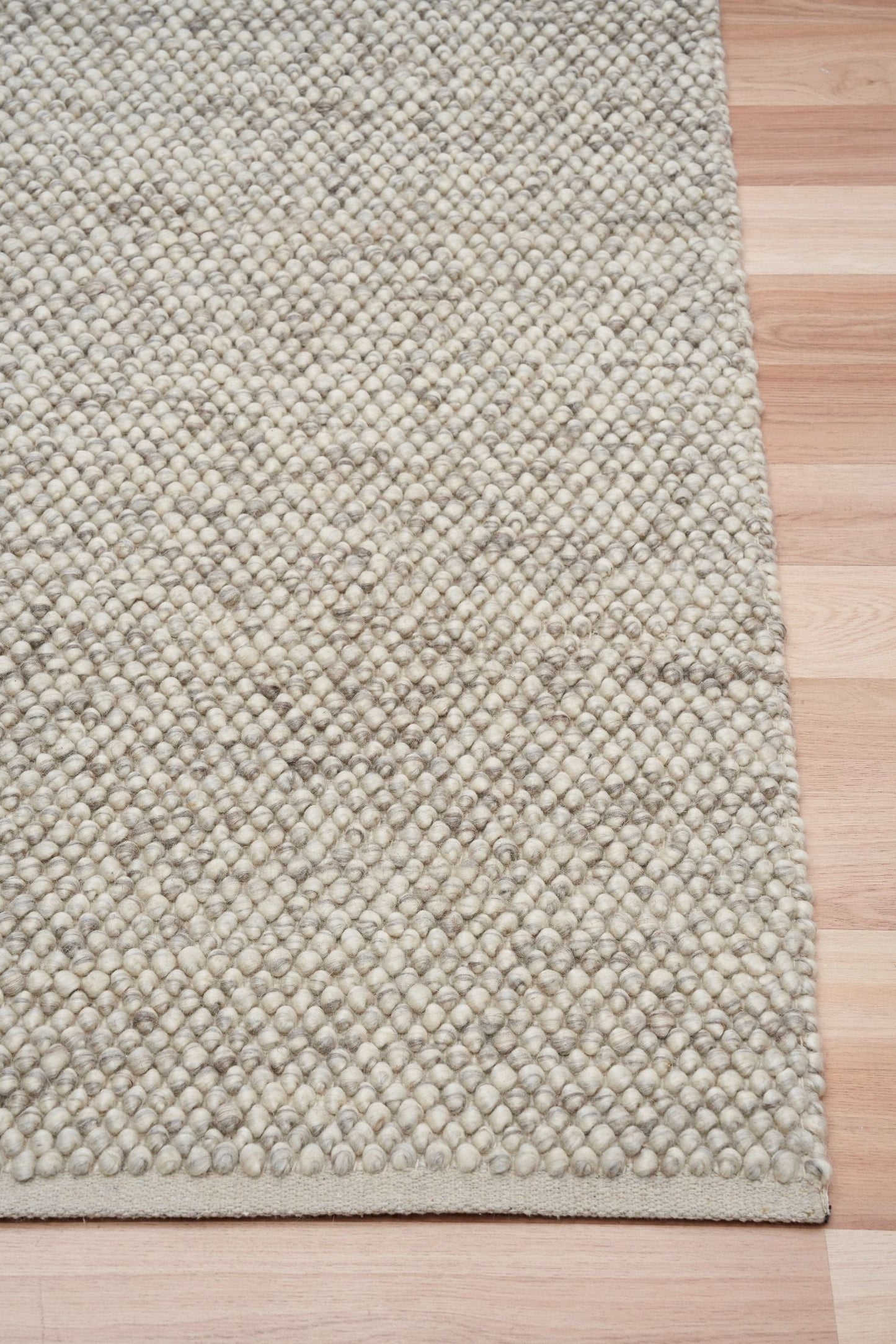 Rusta Silver hand-woven wool rug featuring a looped pile textured design in soft silver tones, ideal for modern and contemporary interiors. Sizes 155 X 225, 200 X 290, 240 X 320 and 300 X 400. Corner.