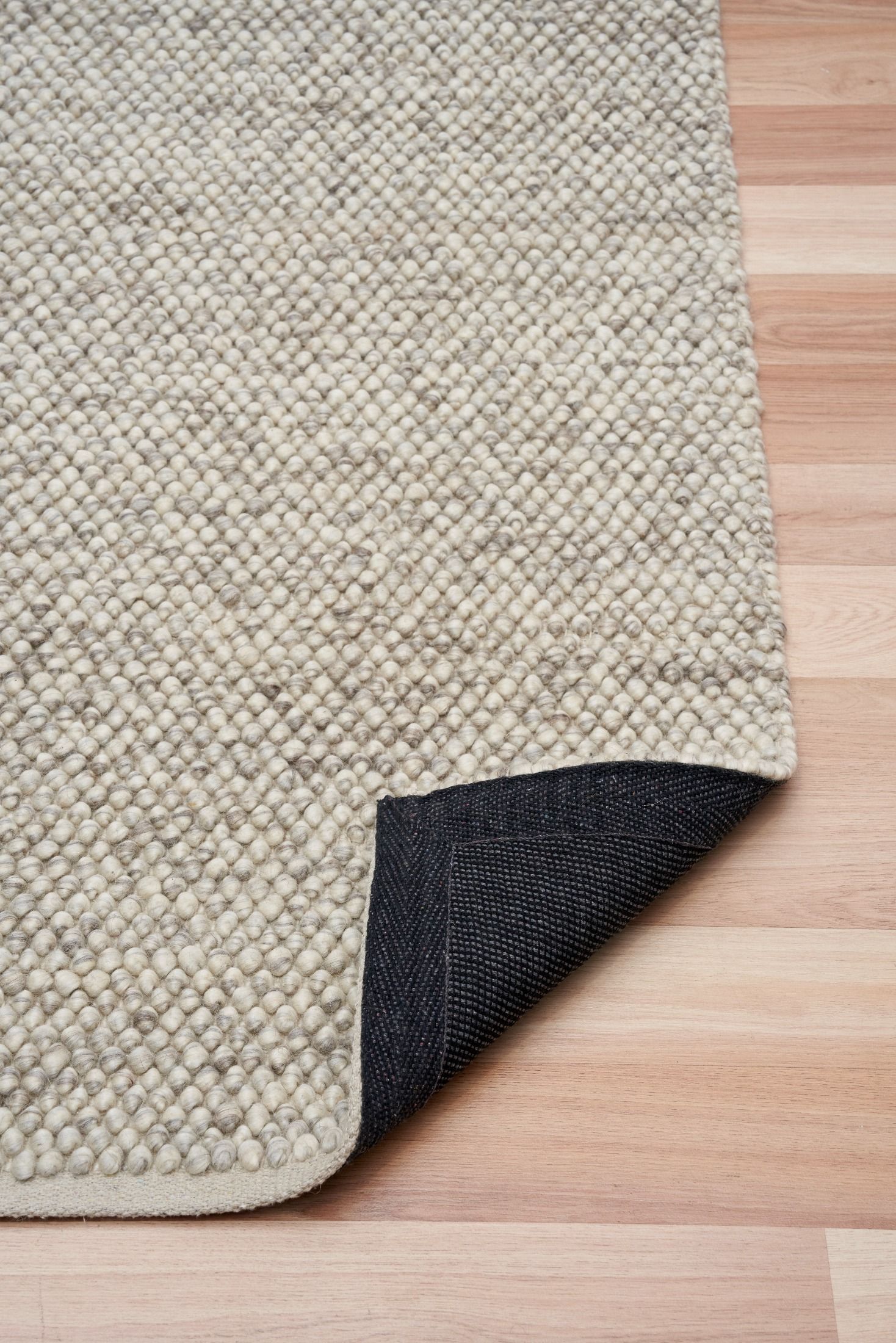 Rusta Silver hand-woven wool rug featuring a looped pile textured design in soft silver tones, ideal for modern and contemporary interiors. Sizes 155 X 225, 200 X 290, 240 X 320 and 300 X 400. Fold.