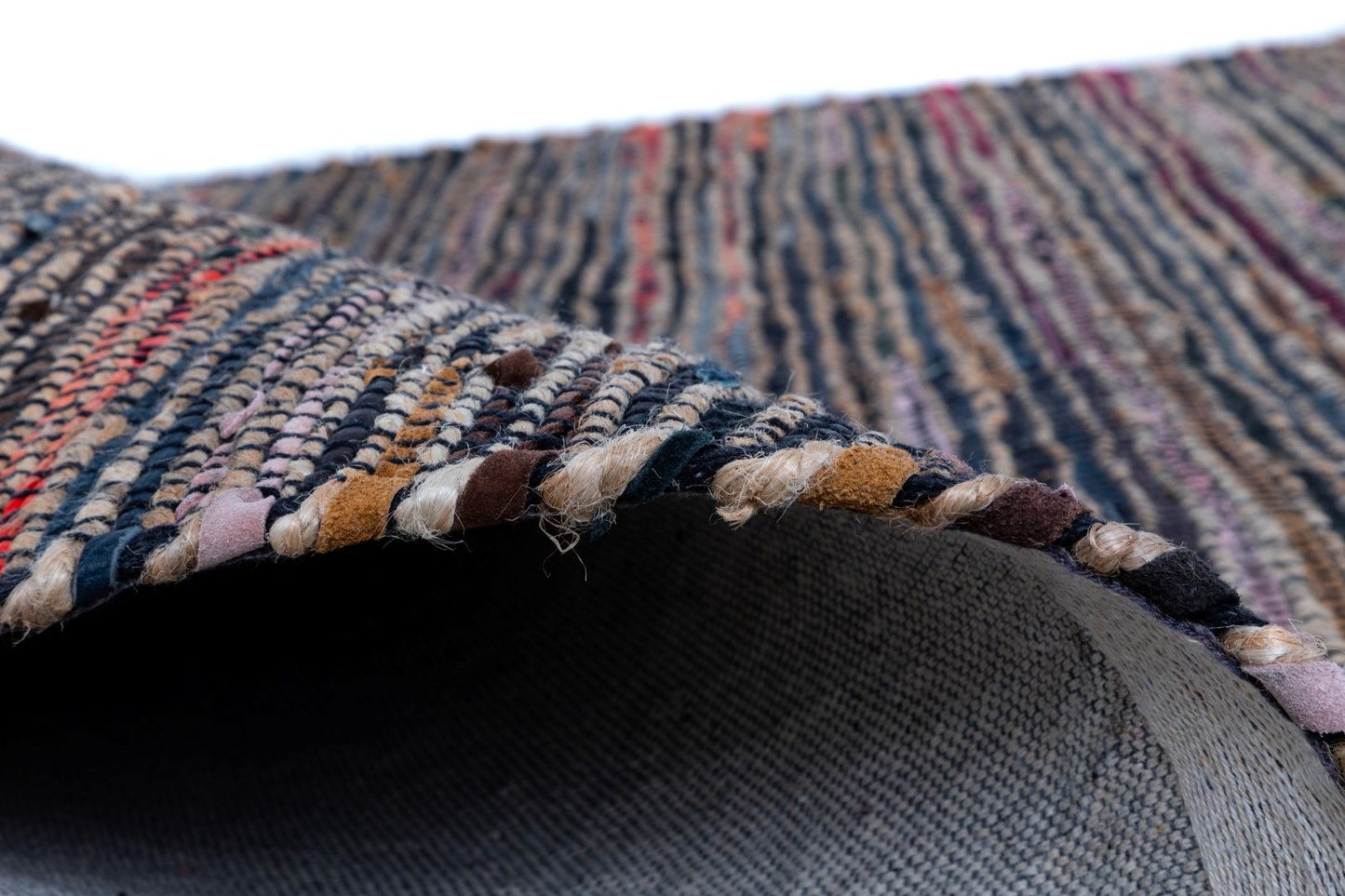 Rustic Charm Multi is a hand woven natural jute and leather carpet.  Colour Black with a multi colour accents. Sizes 155 X 225, 200 X 290, 240 X 320 and 300 X 400. Side.
