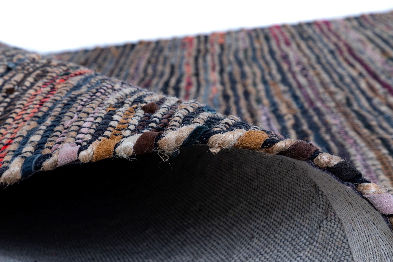 Rustic Charm Multi is a hand woven natural jute and leather carpet.  Colour Black with a multi colour accents. Sizes 155 X 225, 200 X 290, 240 X 320 and 300 X 400. Side.