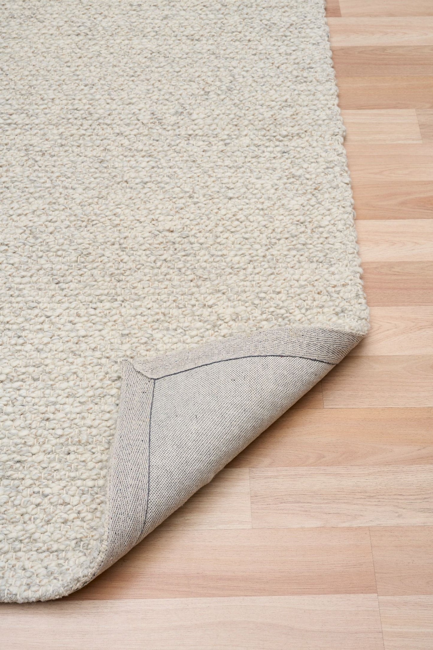 Sahara Grey Rug – hand woven 100% wool rug in soft neutral tones with a textured finish, available in three sizes, styled for modern and coastal homes. Fold.