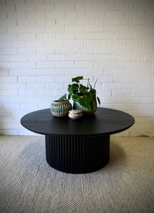 The Santana - Black Coffee Table is a contemporary centrepiece. It features a round table top and textured column base. Colour black. Measures 1000 diameter X 400 height. Styled.