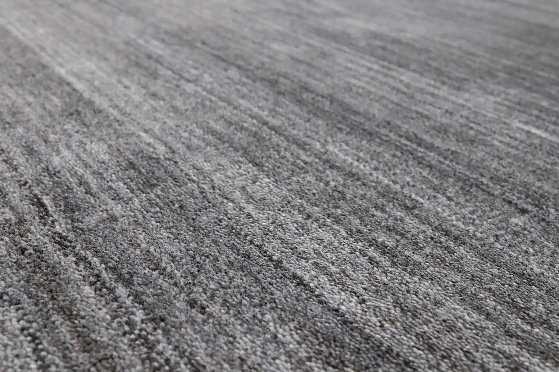 Shadow Fossil is a hand-tufted rug from a blend of wool and silky viscose with a smooth pile and a 12-14mm pile height. Colour Silver with light grey and black accents. Sizes 160 X 230, 200 X 290 and 240 X 340. Angle.
