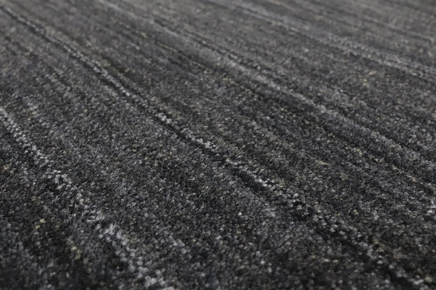 Shadow Smoke is a hand-tufted rug from a blend of wool and silky viscose with a smooth pile and a 12-14mm pile height. Colour black with light grey and silver accents. Sizes 160 X 230, 200 X 290 and 240 X 340. Angle.