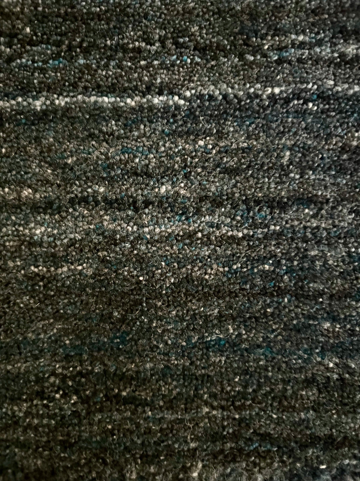 Shadow Smoke is a hand-tufted rug from a blend of wool and silky viscose with a smooth pile and a 12-14mm pile height. Colour black with light grey and silver accents. Sizes 160 X 230, 200 X 290 and 240 X 340. Close.
