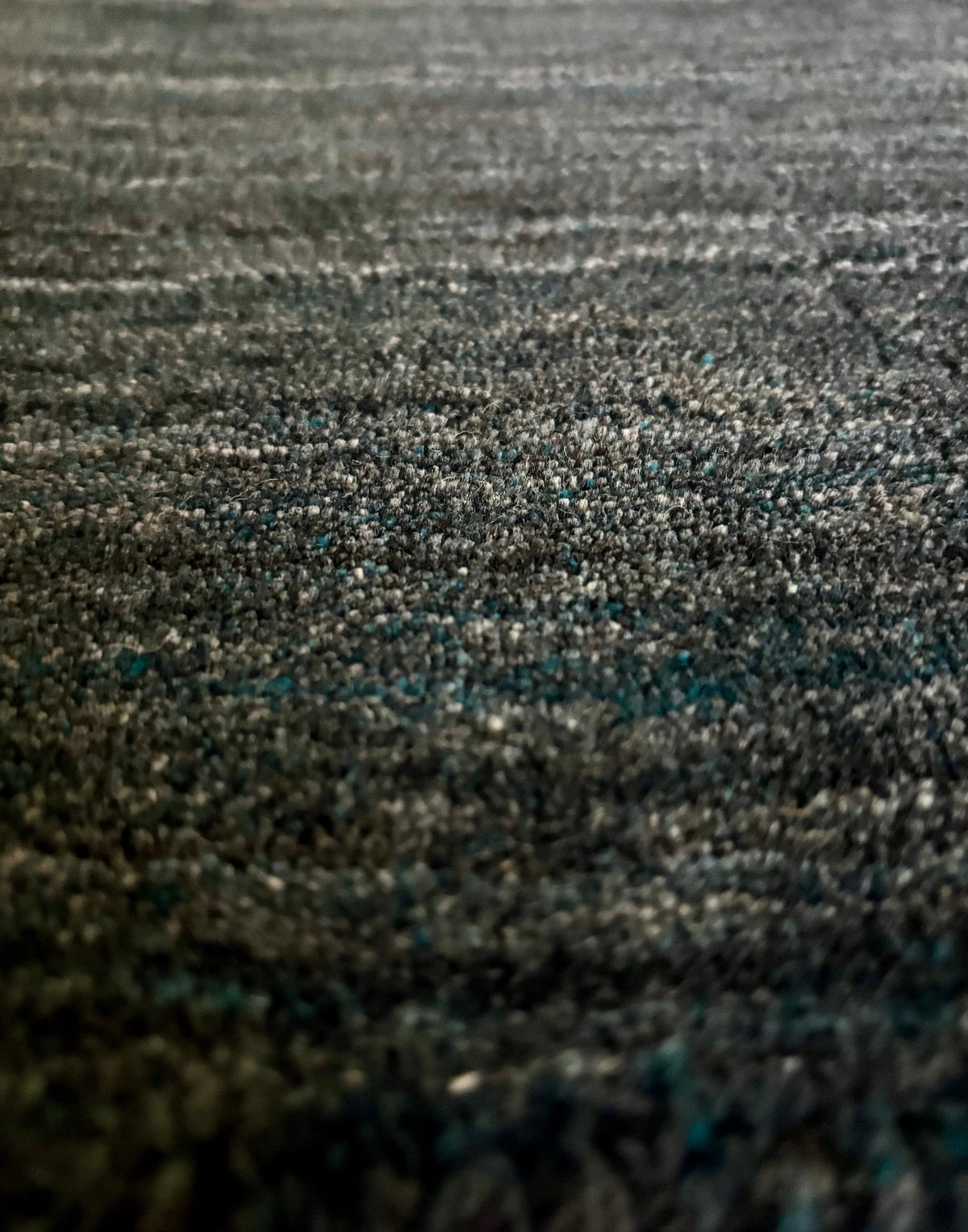 Shadow Smoke is a hand-tufted rug from a blend of wool and silky viscose with a smooth pile and a 12-14mm pile height. Colour black with light grey and silver accents. Sizes 160 X 230, 200 X 290 and 240 X 340. Close Angle.