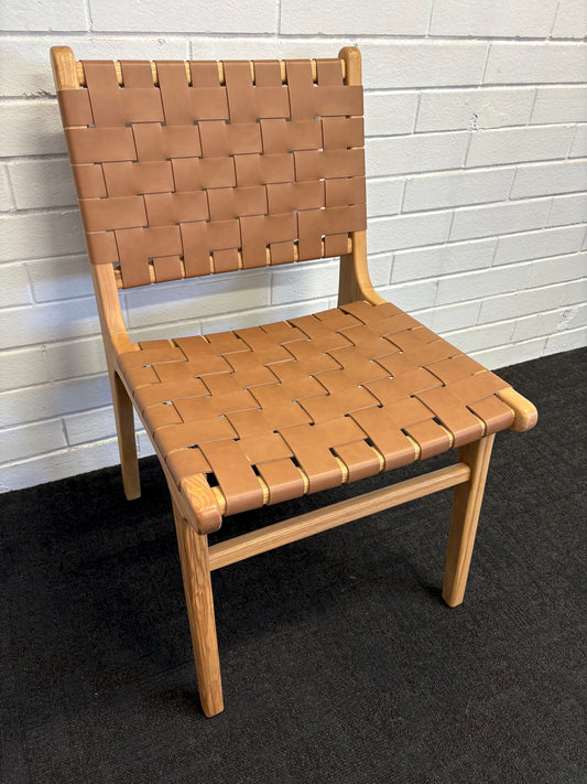 The Shawnee - Tan Dining Chair, features an ash frame and tan saddle leather. It has a strapped seat and back. Colours, natural frame with tan leather. Measures 510 wide X 420 depth X 460 Seat height. Back height 840. Angle.