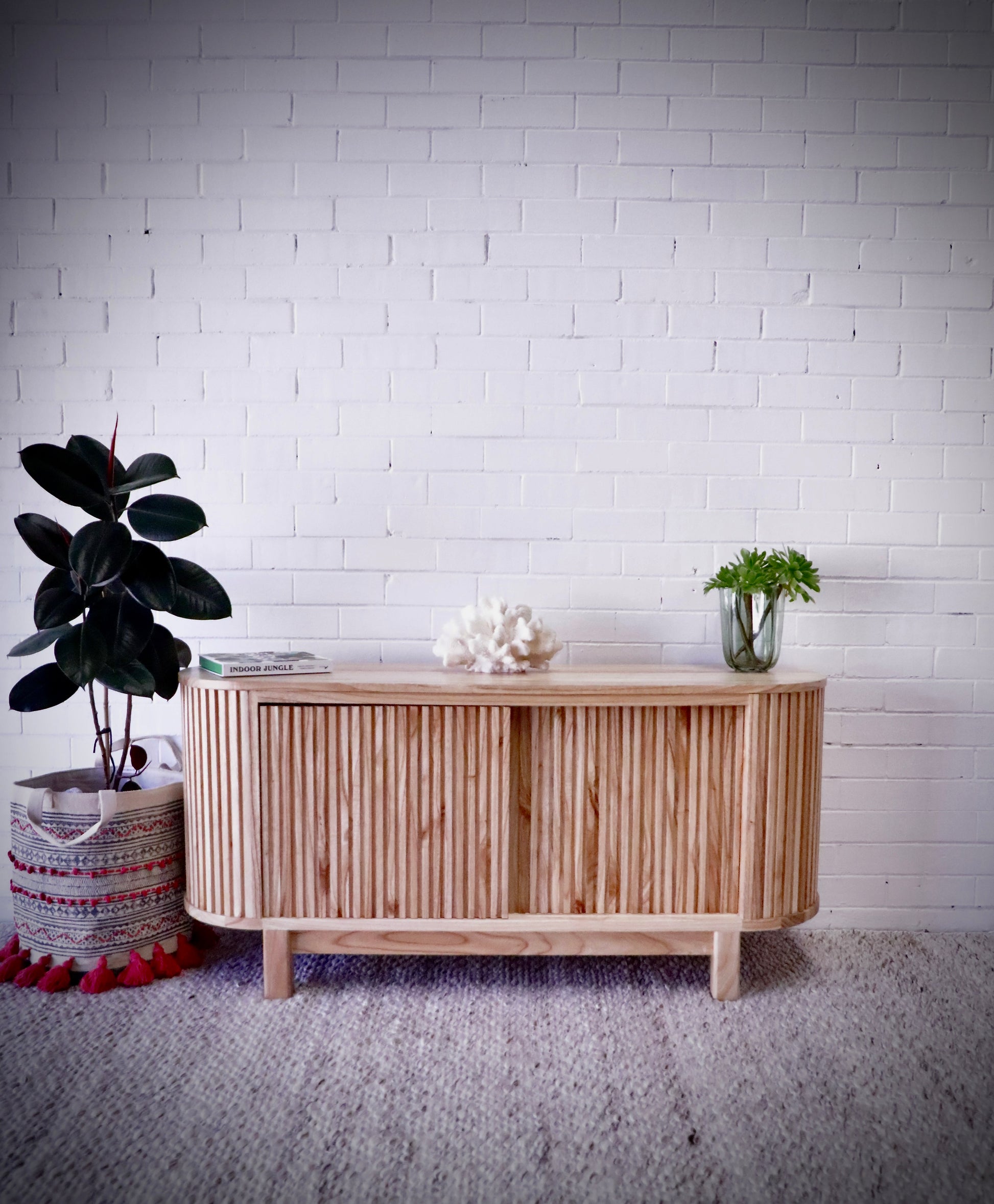 The Sisters 2 Sliding Door Buffett is crafted from white cedar, it features a contemporary design with sleek curved ends and two sliding doors. Colour natural. Measures 1500 length X 450 depth X 700 height. Styled.