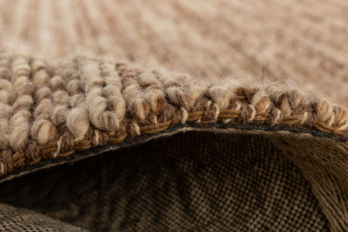 Svend Taupe is a contemporary hand woven braided pile wool rug.  Colours Taupe Brown with Beige accents. Sizes 155 X 225, 200 X 290, 240 X 320 and 300 X 400. Side.