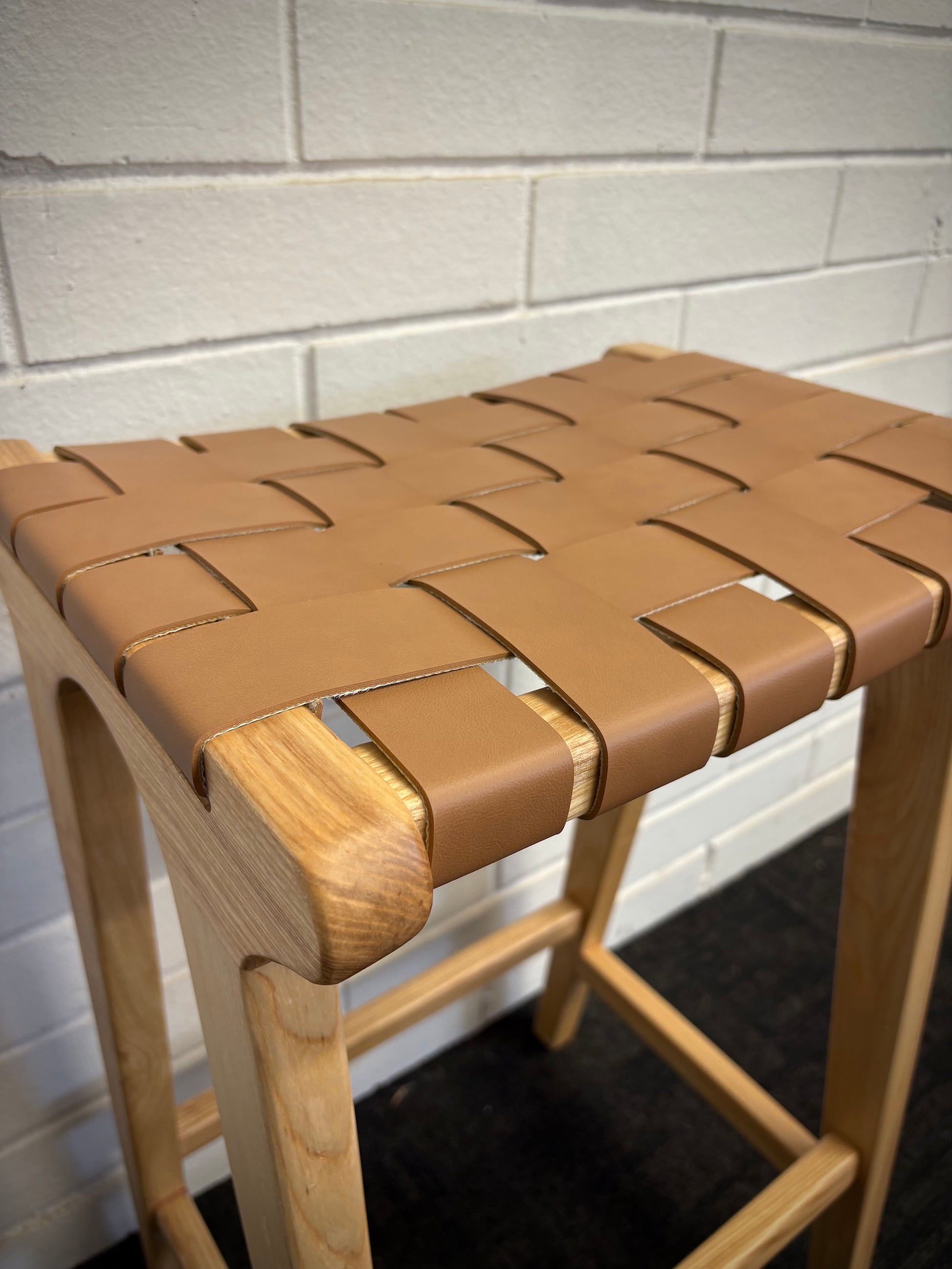 The Thames Barstool, tan leather, is designed with a contemporary style. Featuring a sustainable ash frame and a luxurious strapped saddle leather seat. Colour natural frame with tan leather. Measures 410 wide X 320 depth X 640 height. Close.