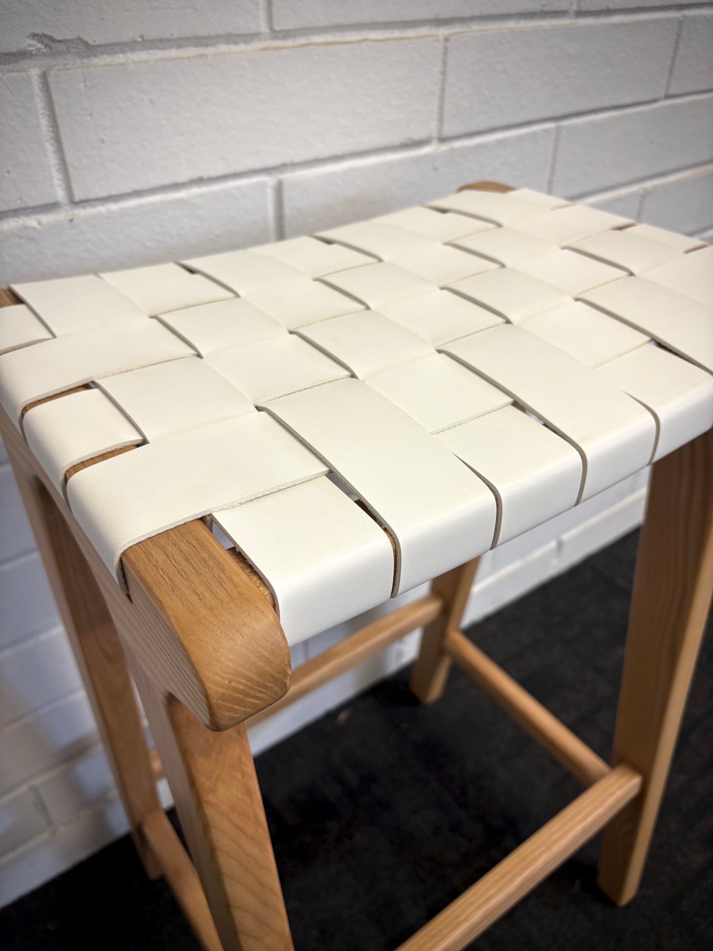 The Thames - White Leather Barstool, is designed with a contemporary style. Featuring a sustainable ash frame and a luxurious strapped saddle leather seat. Colour natural frame with white leather. Measures 410 wide X 320 depth X 640 height. Close.