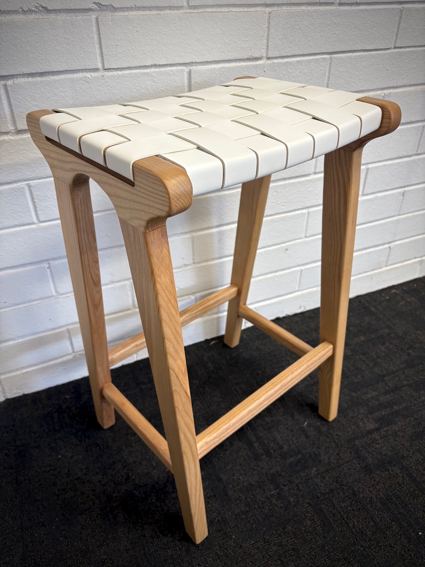 The Thames - White Leather Barstool, is designed with a contemporary style. Featuring a sustainable ash frame and a luxurious strapped saddle leather seat. Colour natural frame with white leather. Measures 410 wide X 320 depth X 640 height. Side.