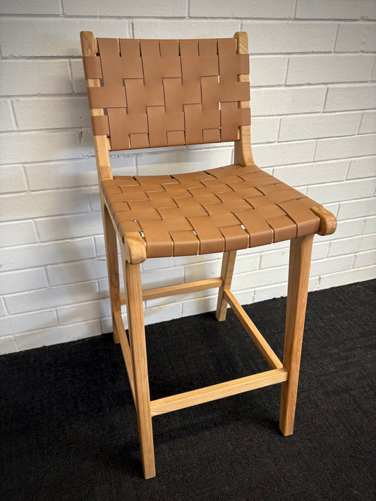 The Thames w/back Tan Leather barstool features black strapped saddle leather on an ash frame. measures 410 wide X 320 depth X 660 seat height. Angle.