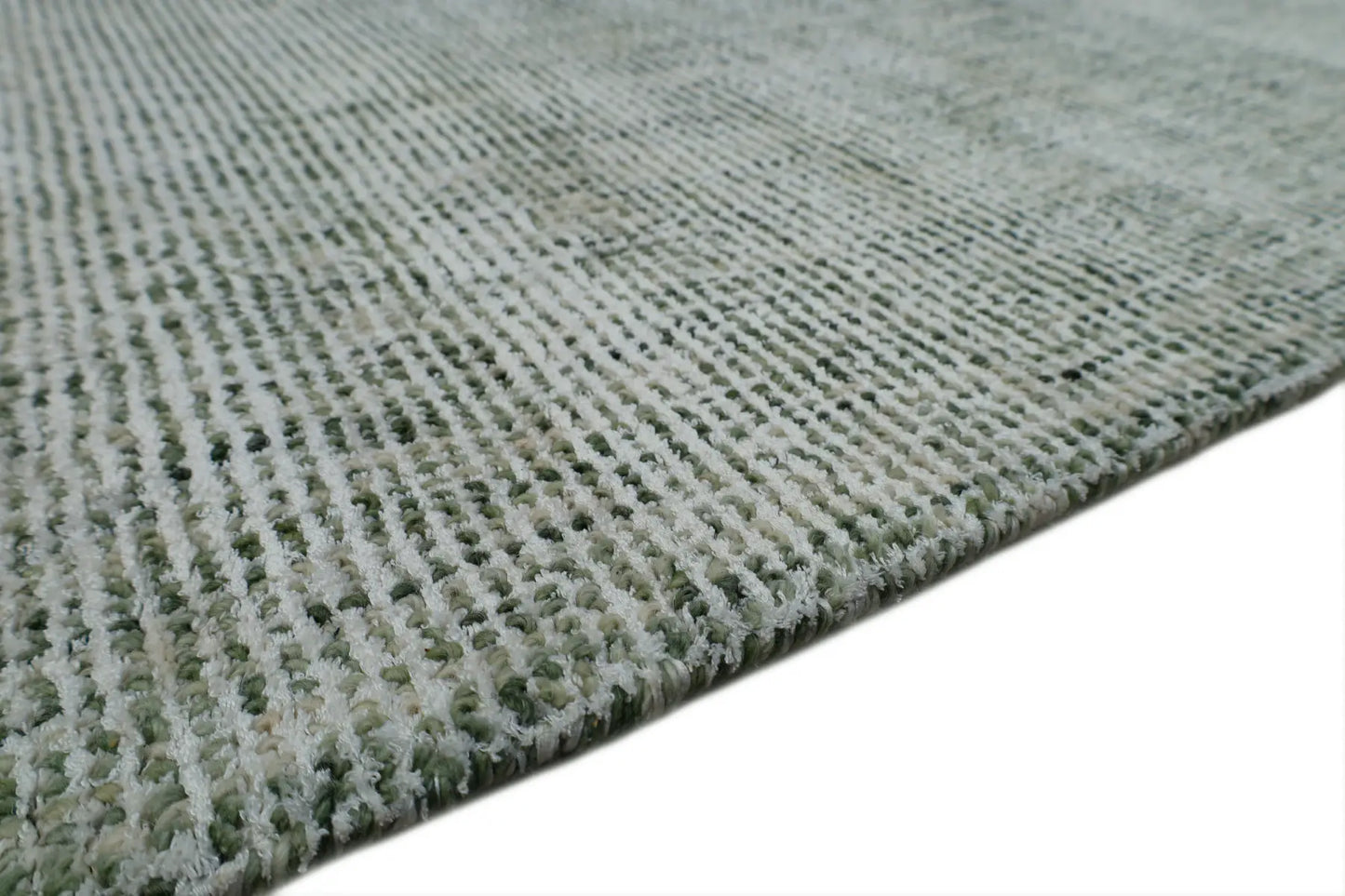 Toro Green is a hand-loomed, hand-knotted rug with a contemporary multi-fleck design. Wool and silky viscose are blended to create a soft feel with its 10-12mm pile height. Colour emerald green with white accents. Sizes 160 X 230, 200 X 290, 240 X 340 and 300 X 400. Side.