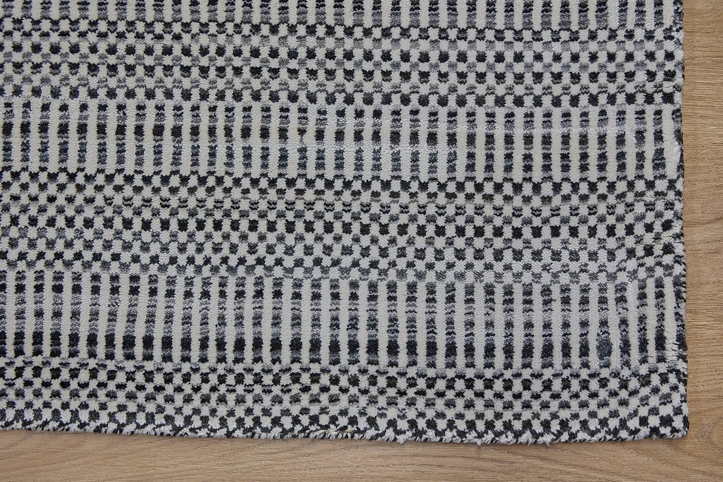 Tulip Black is a contemporary rug crafted with a blend of wool and bamboo silk for a soft, medium-textured look. Its boasts a pile height of 10-12mm. Colour black and white. Sizes 160 X 230, 200 X 290 and 240 X 340. Corner.