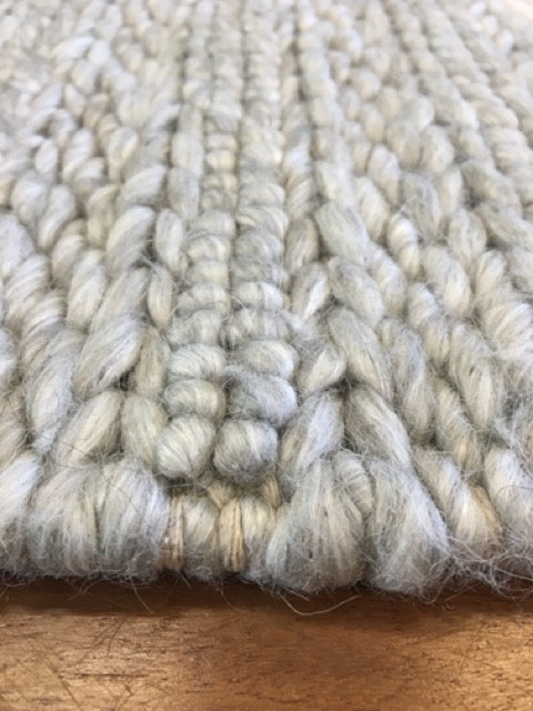 Vaucluse Silver Grey is a textured hand woven loop pile and braided loop wool and viscose rug. It features a contemporary design. Colours Silver with Grey accents. Sizes 155 X 225, 200 X 290, 240 X 340 and 300 X 400. Angle.