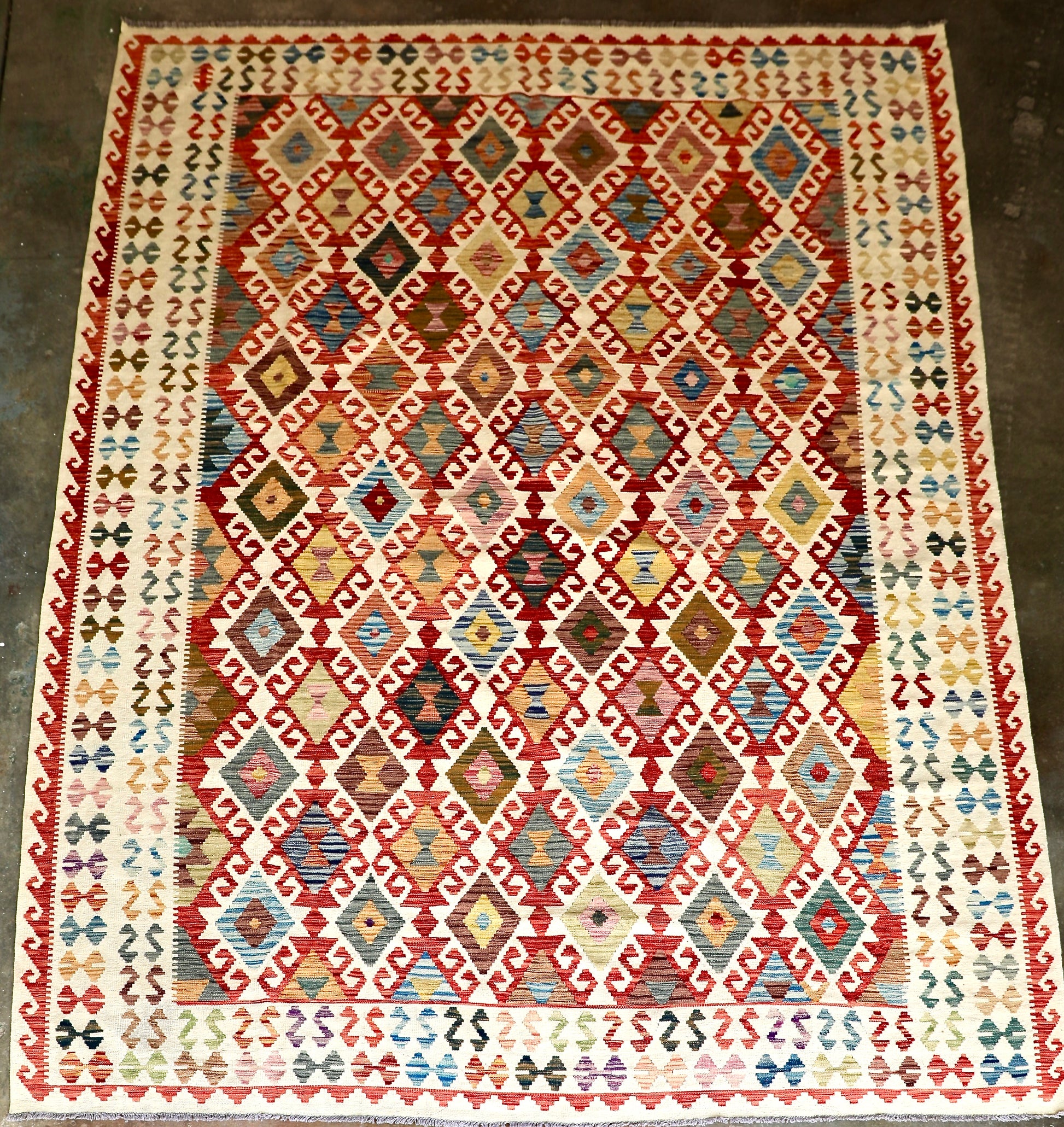 The Afghan Hand Woven Khyber Kilim - 278 X 376. Crafted using traditional vegetable dyed wool, and featuring traditional geometric designs. Colours, cream, blues, reds, oranges, yellow and teals. Size 278 X 376. Plain.