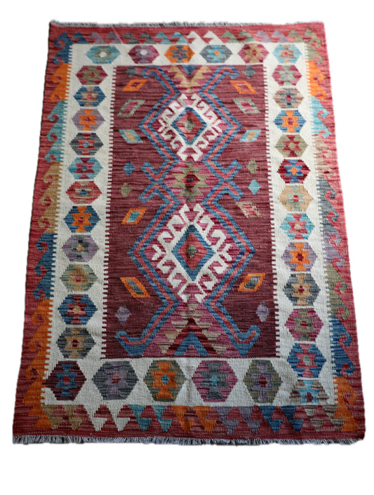 The Afghan Hand Woven Khyber Kilim 122 X 183. Crafted using traditional vegetable dyed wool, and featuring traditional geometric designs. Colours, reds, oranges, browns, creams and teal greens. Size 122 X 183. Cover.