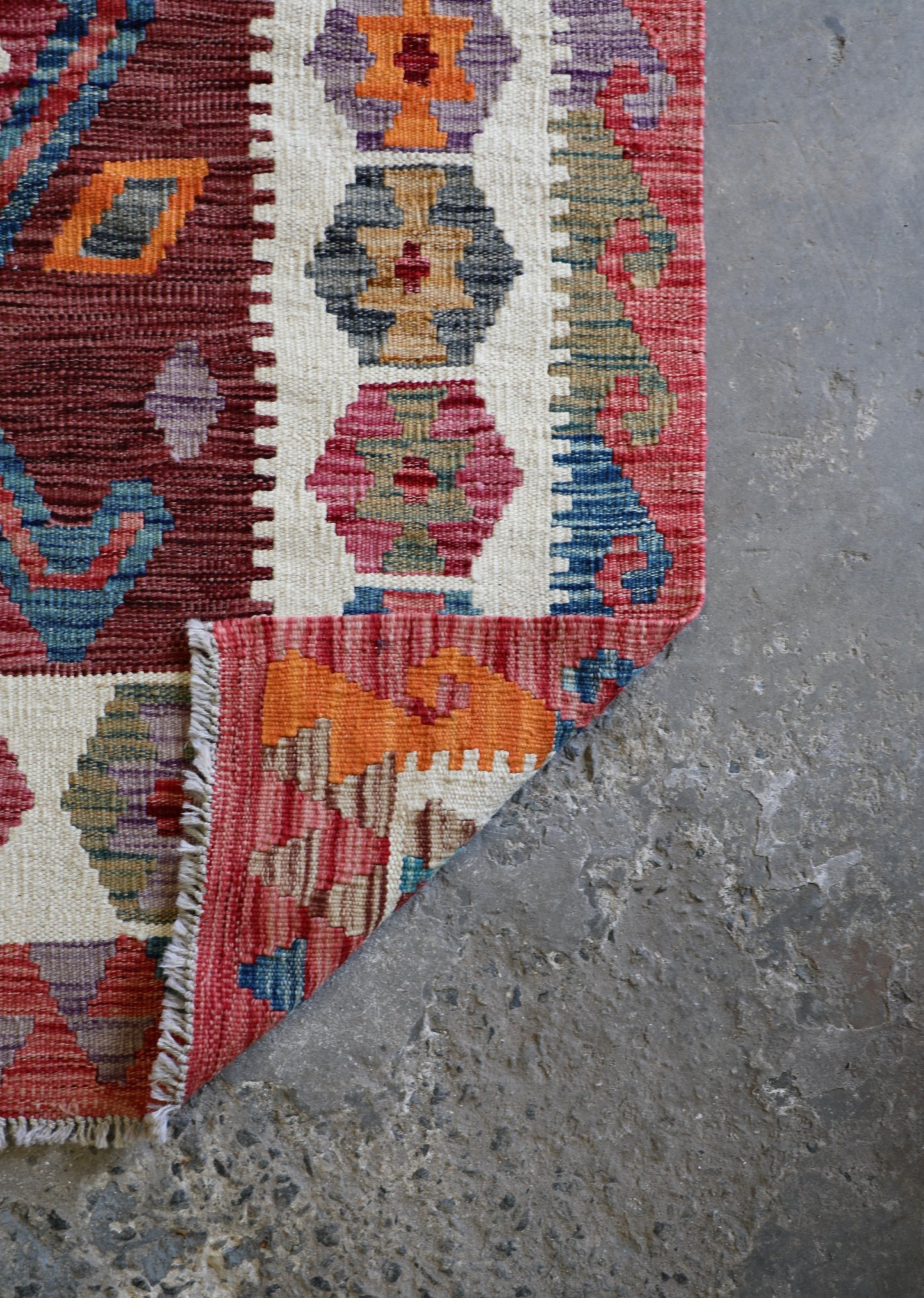 The Afghan Hand Woven Khyber Kilim 122 X 183. Crafted using traditional vegetable dyed wool, and featuring traditional geometric designs. Colours, reds, oranges, browns, creams and teal greens. Size 122 X 183. Fold.
