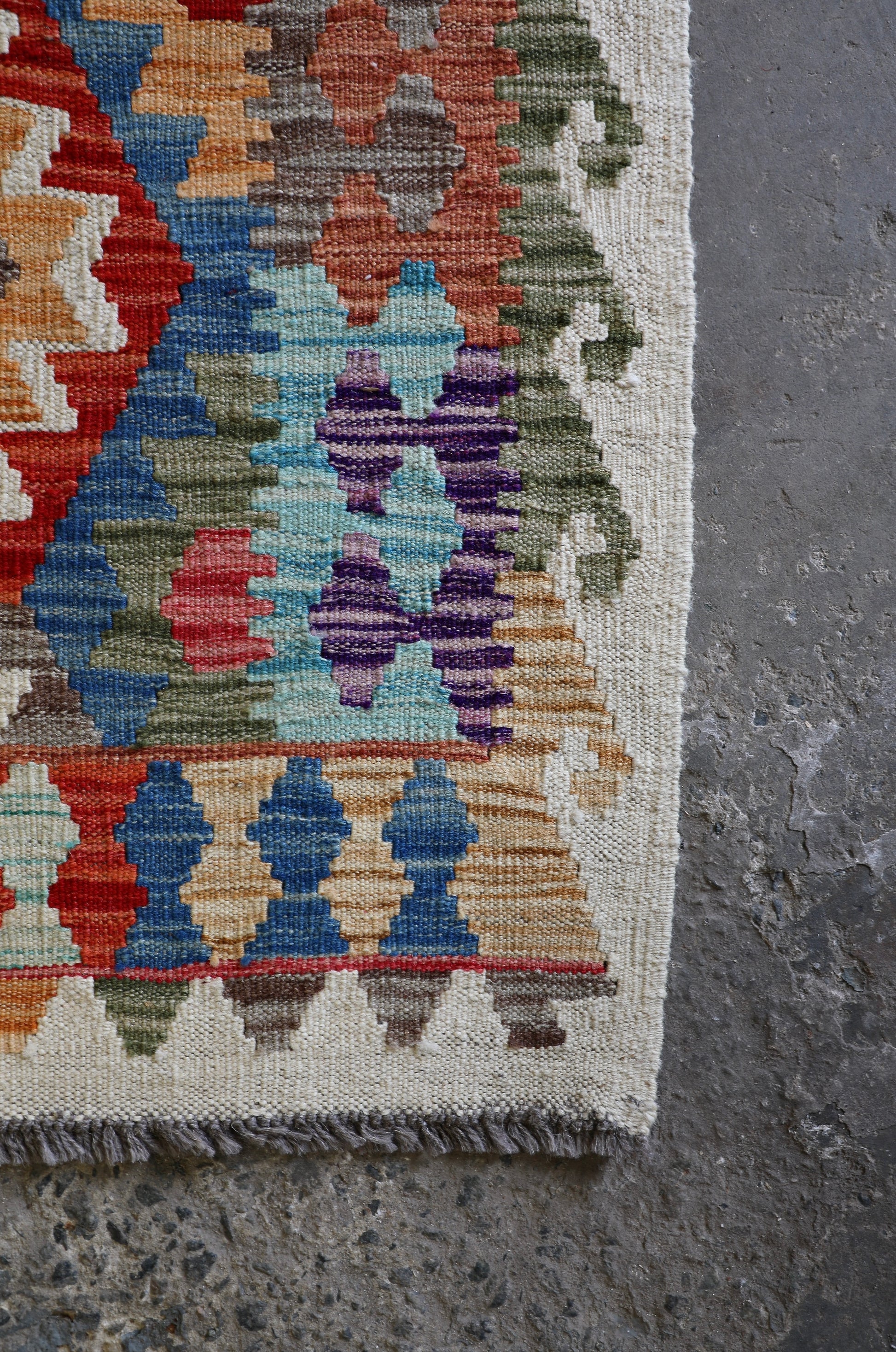 The Afghan Khyber Kilim - 126 X 178.  Crafted using traditional vegetable dyed wool, and featuring traditional geometric designs. Colours, Beige, blue, red, yellow brown. Size 126 X 178. Corner.