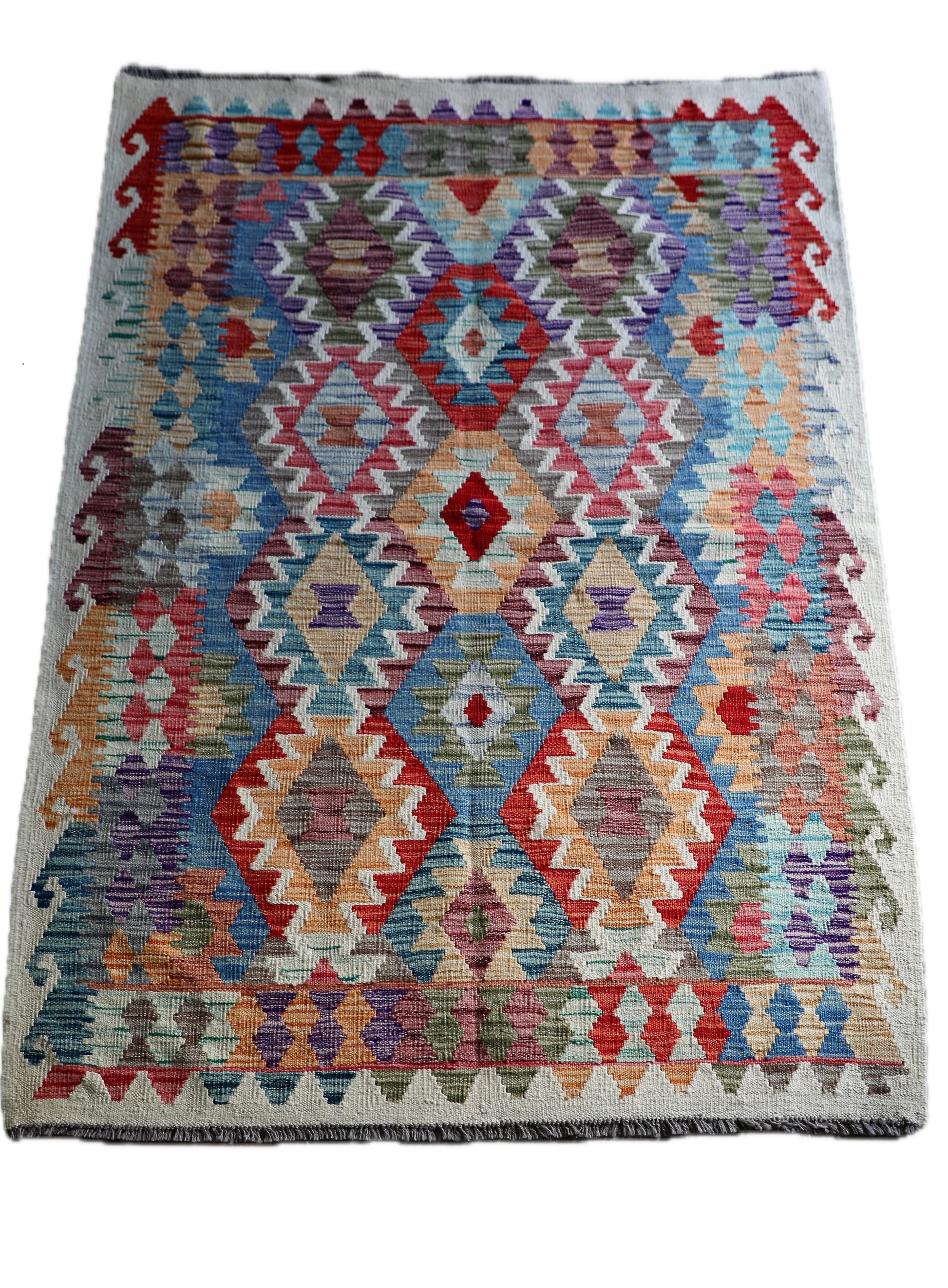 The Afghan Khyber Kilim - 126 X 178.  Crafted using traditional vegetable dyed wool, and featuring traditional geometric designs. Colours, Beige, blue, red, yellow brown. Size 126 X 178. Cover.