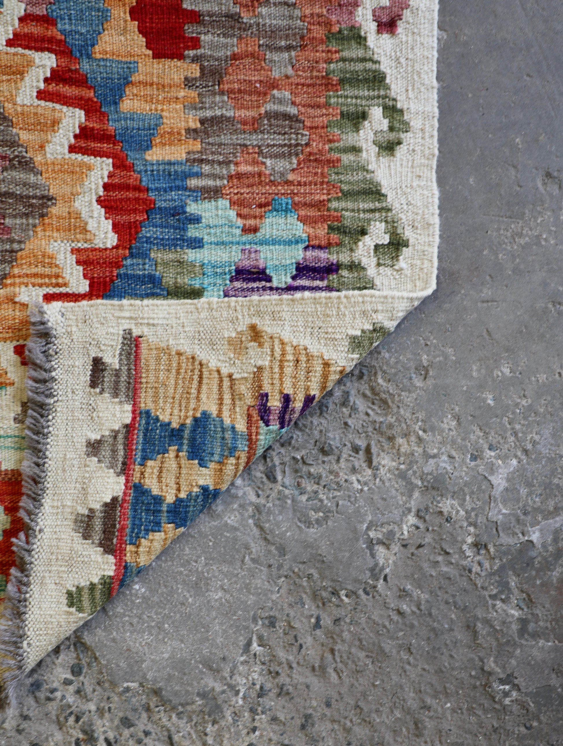 The Afghan Khyber Kilim - 126 X 178.  Crafted using traditional vegetable dyed wool, and featuring traditional geometric designs. Colours, Beige, blue, red, yellow brown. Size 126 X 178. Fold.