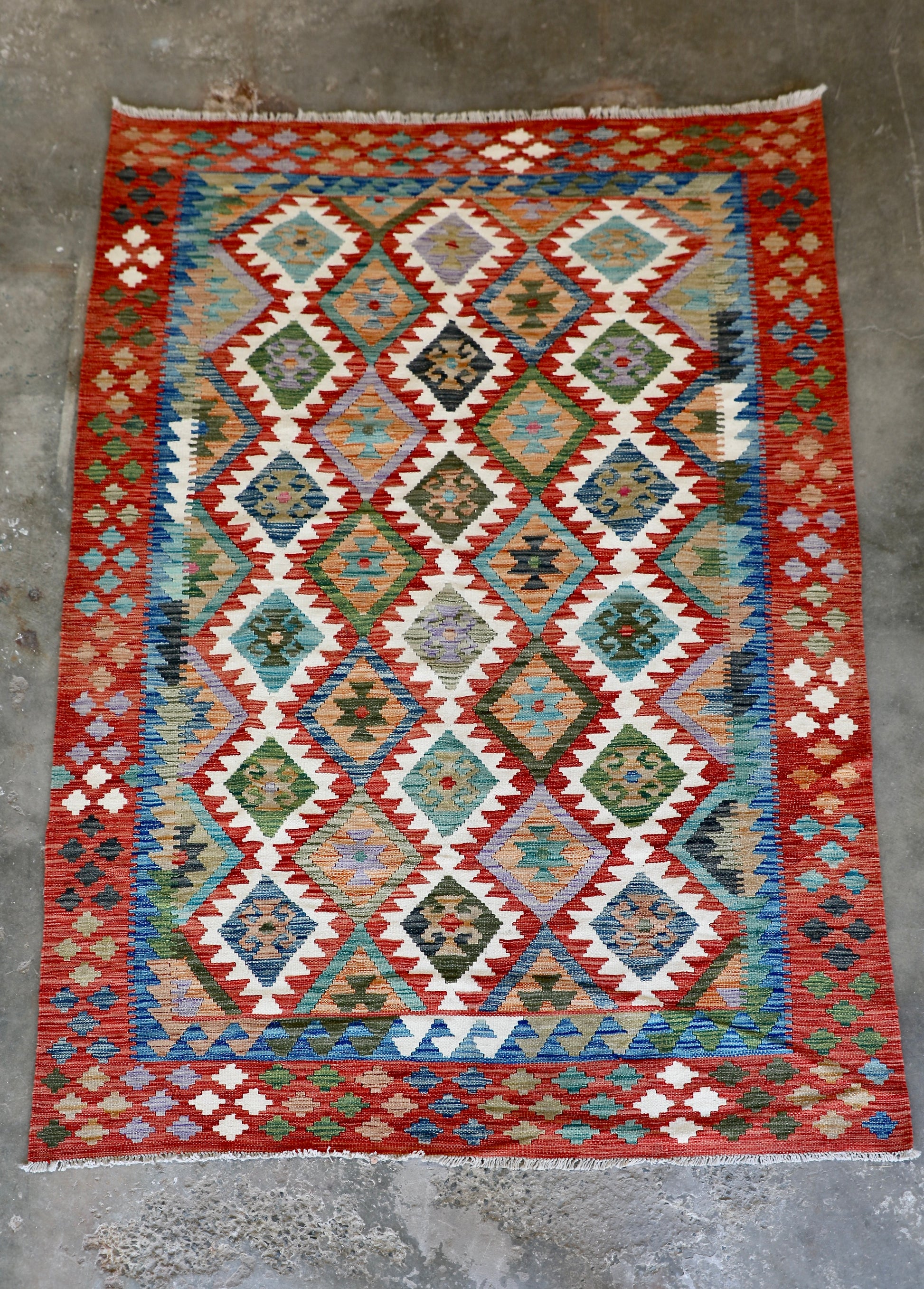 The Afghan Hand Woven Khyber Kilim - 172 X 250. Crafted using traditional vegetable dyed wool, and featuring traditional geometric designs. Colours, cream, reds, greens, blues, oranges. Size 172 X 250. Front.