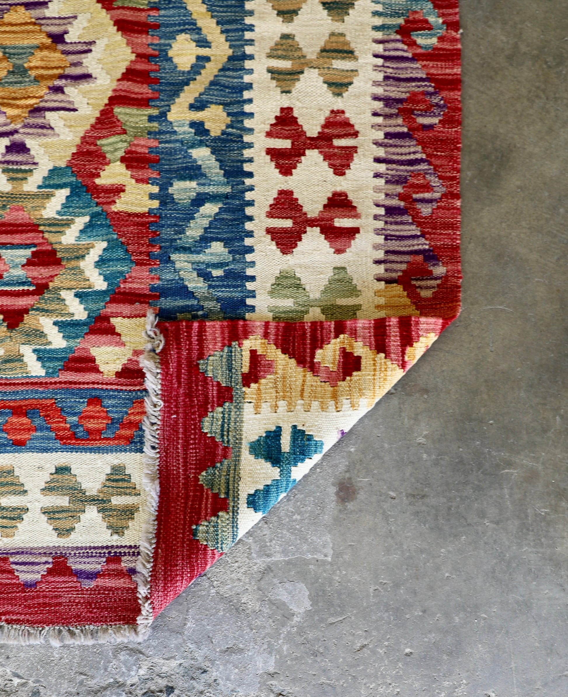 The Afghan Hand Woven Khyber Kilim - 175 X 240. Crafted using traditional vegetable dyed wool, and featuring traditional geometric designs. Colours, red, blue, yellow, teal, beige. Size 175 X 240. Fold.