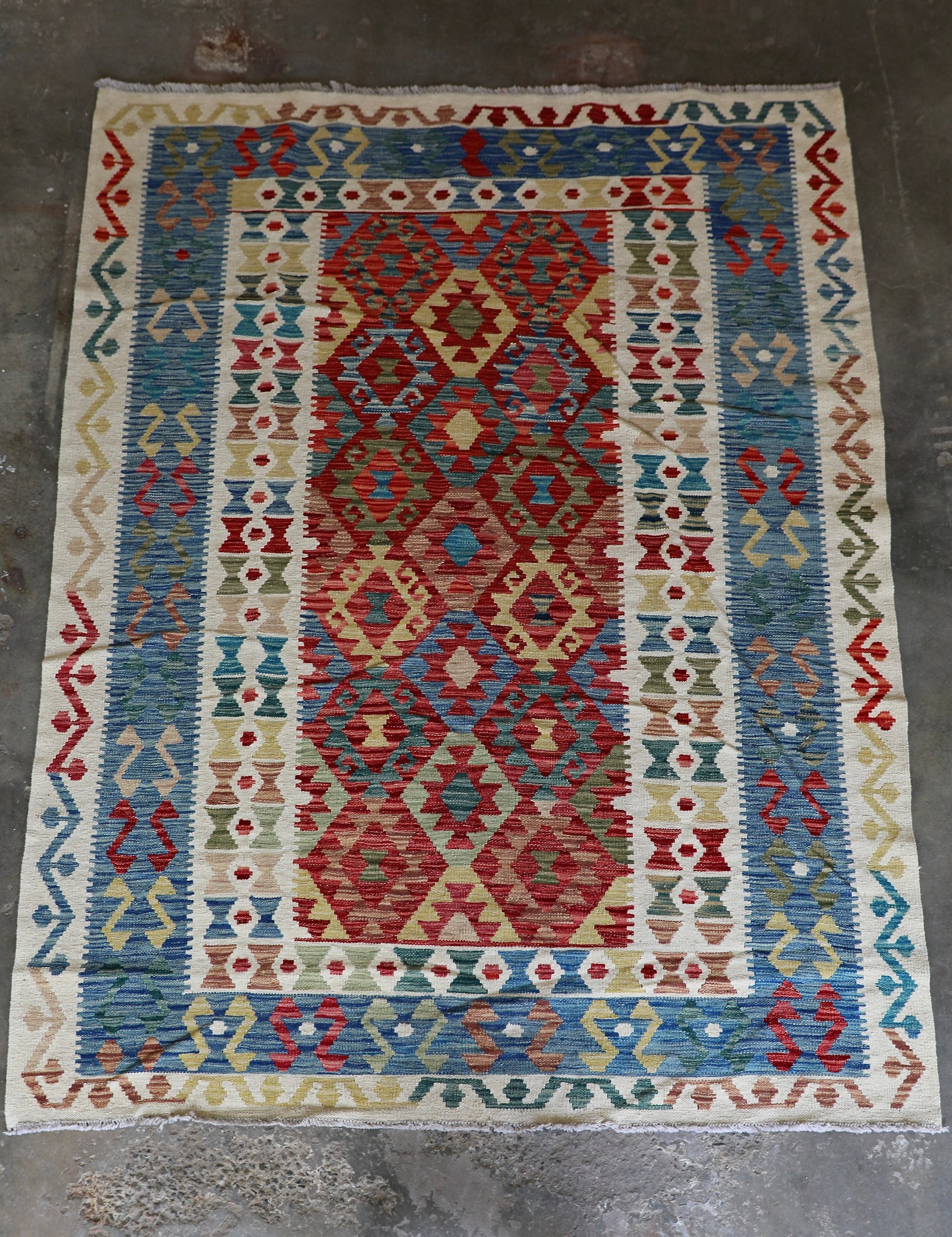 The Afghan Hand Woven Khyber Kilim - 180 X 248. Crafted using traditional vegetable dyed wool, and featuring traditional geometric designs. Colours, cream, blues, greens, reds, oranges. Size 180 X 248. Front.