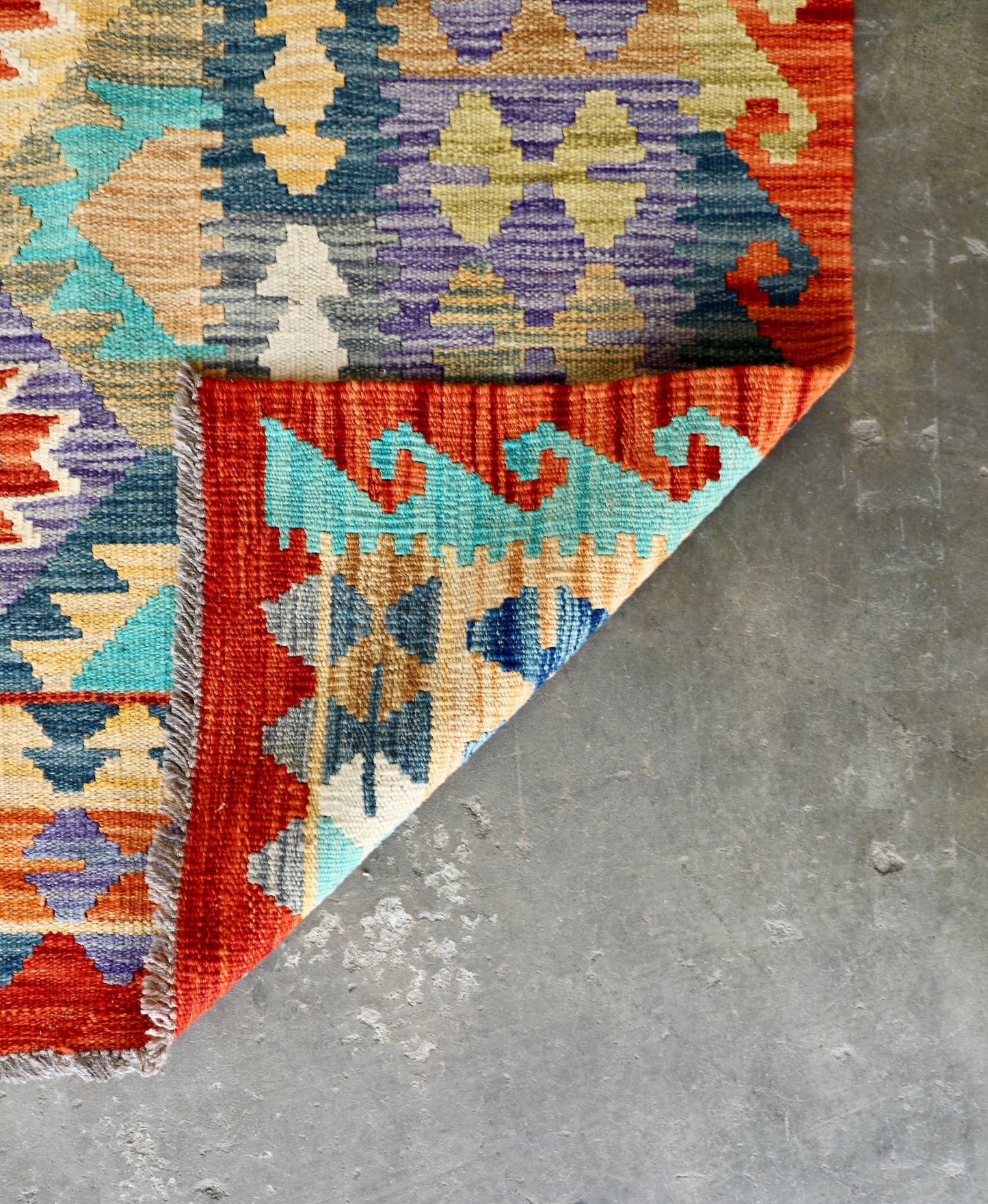 The Afghan Hand Woven Khyber Kilim - 202 X 286. Crafted using traditional vegetable dyed wool, and featuring traditional geometric designs. Colours, reds, blues, greens, yellows and oranges. Size 202 X 286. Fold.