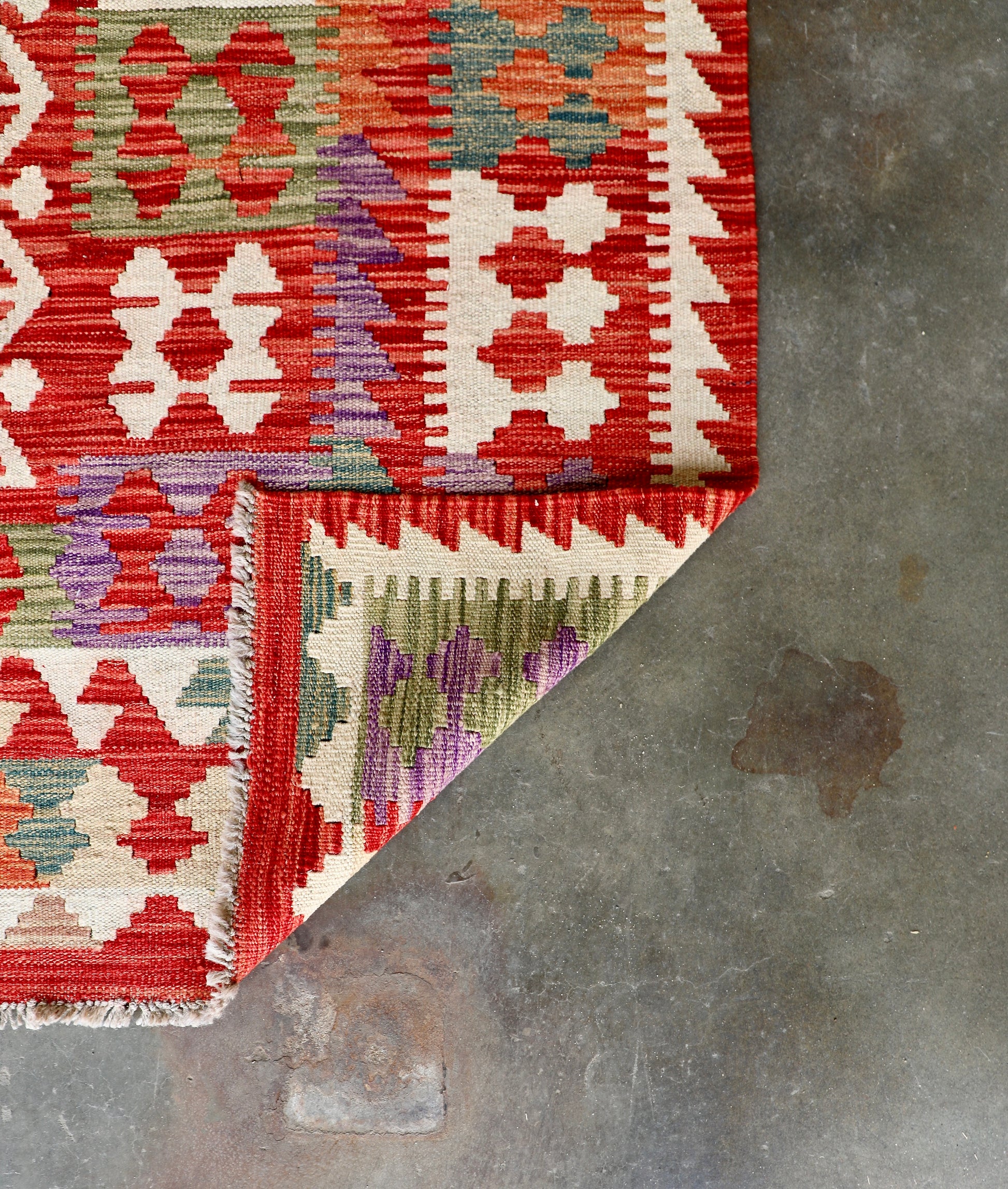 The Afghan Hand Woven Khyber Kilim - 252 X 345. Crafted using traditional vegetable dyed wool, and featuring traditional geometric designs. Colours, Oranges, reds, creams, teals. Size 252 X 345. Fold.