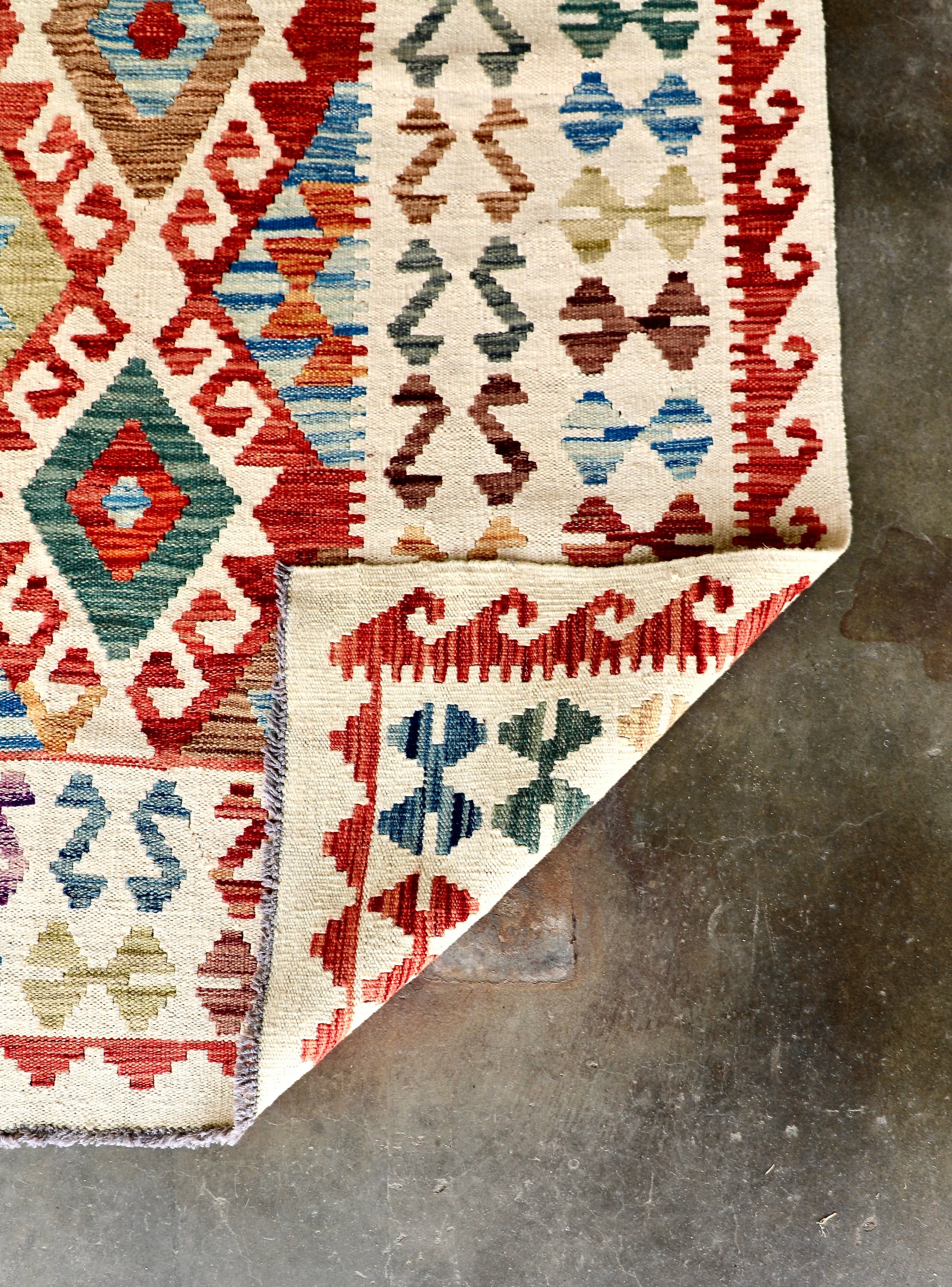 The Afghan Hand Woven Khyber Kilim - 278 X 376. Crafted using traditional vegetable dyed wool, and featuring traditional geometric designs. Colours, cream, blues, reds, oranges, yellow and teals. Size 278 X 376. Fold.