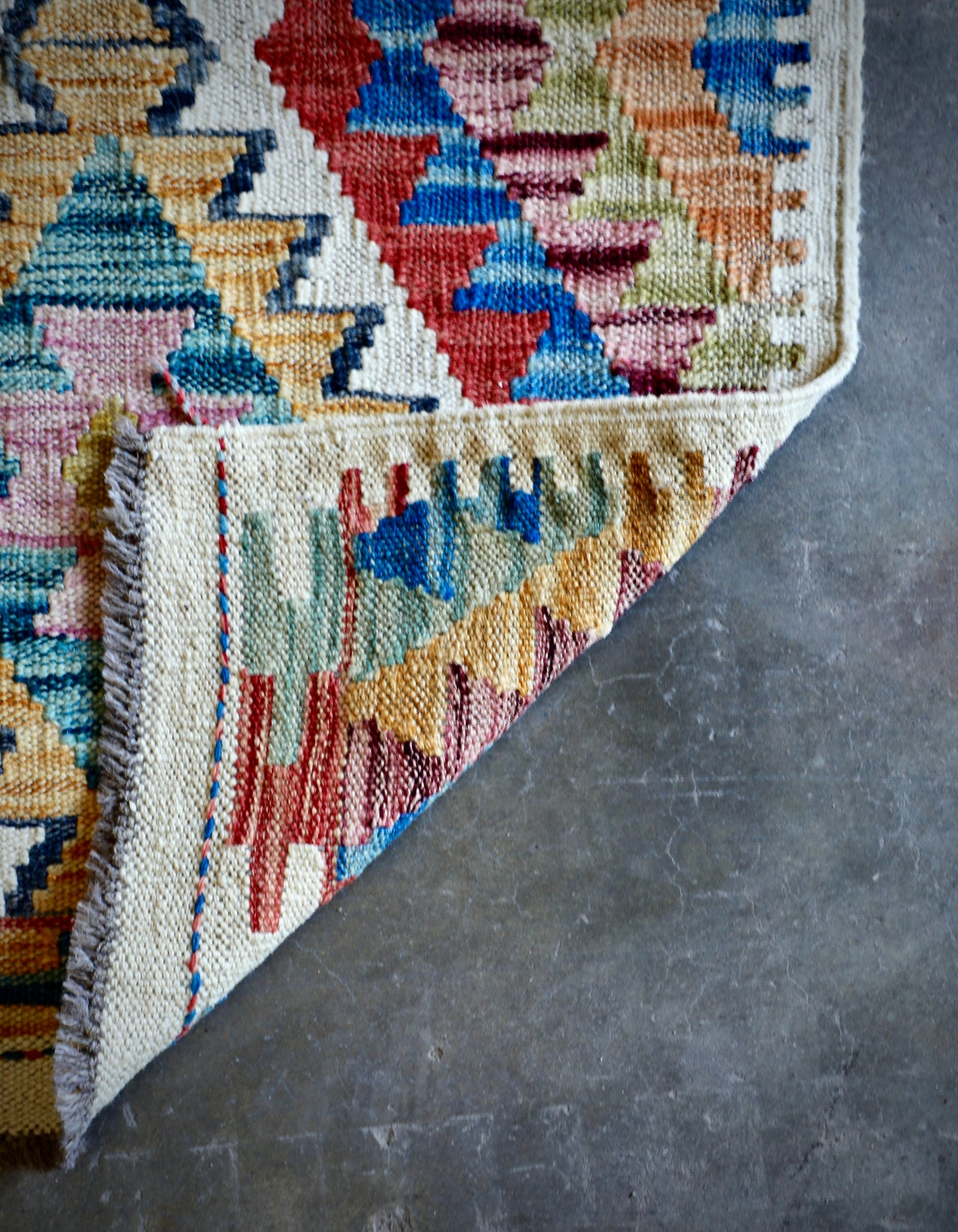 The Afghan Hand Woven Khyber Kilim 66 X 90. Crafted using traditional vegetable dyed wool, and featuring traditional geometric designs. Colours, creams, yellows, oranges, blue and dark greens. Size 66 X 90. Fold.