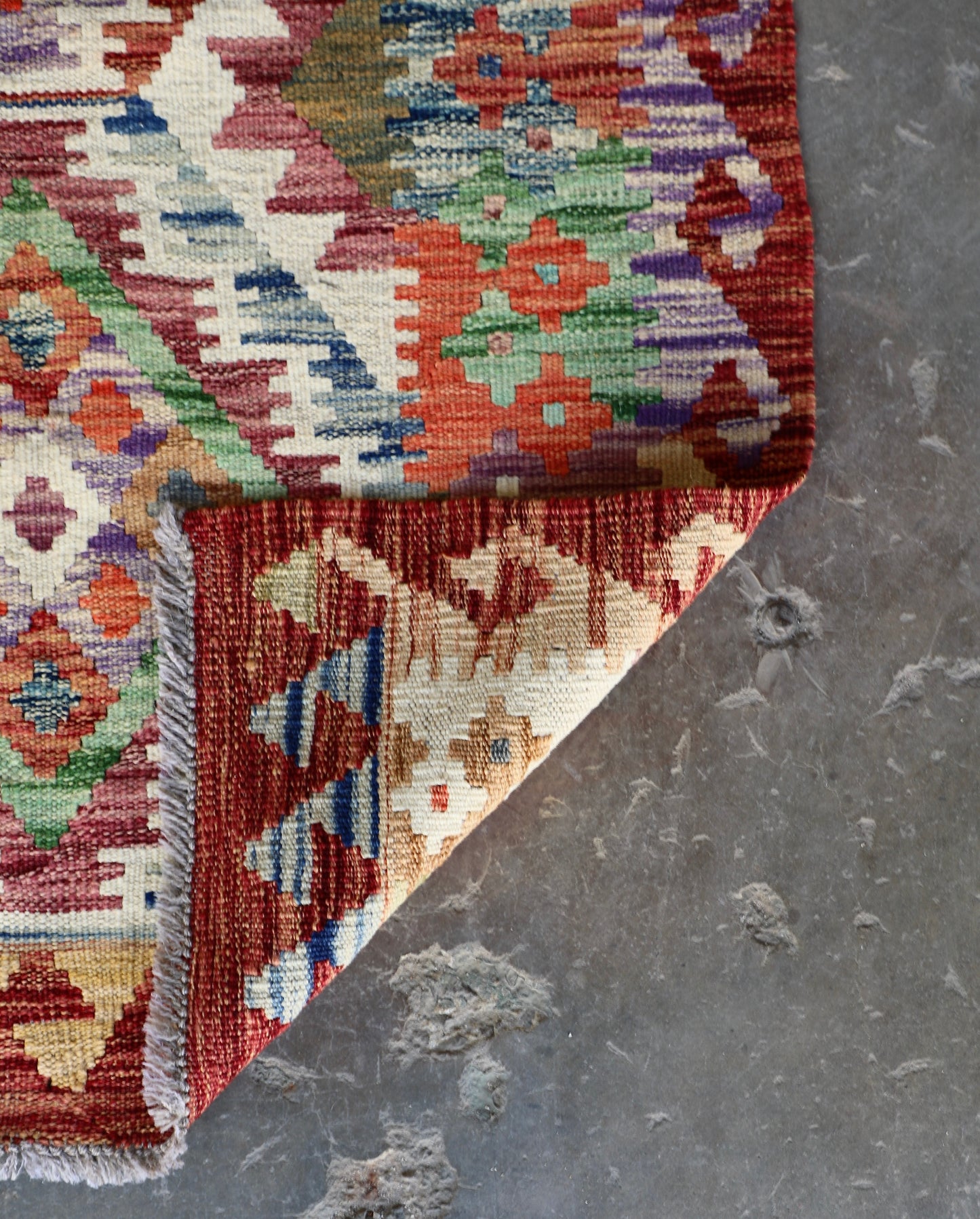 The Afghan Hand Woven Khyber Kilim Runner - 80 X 287. Crafted using traditional vegetable dyed wool, and featuring traditional geometric designs.  Colours, Oranges, reds, yellow, teals and creams. Measures 80 wide X 287 long. Fold.