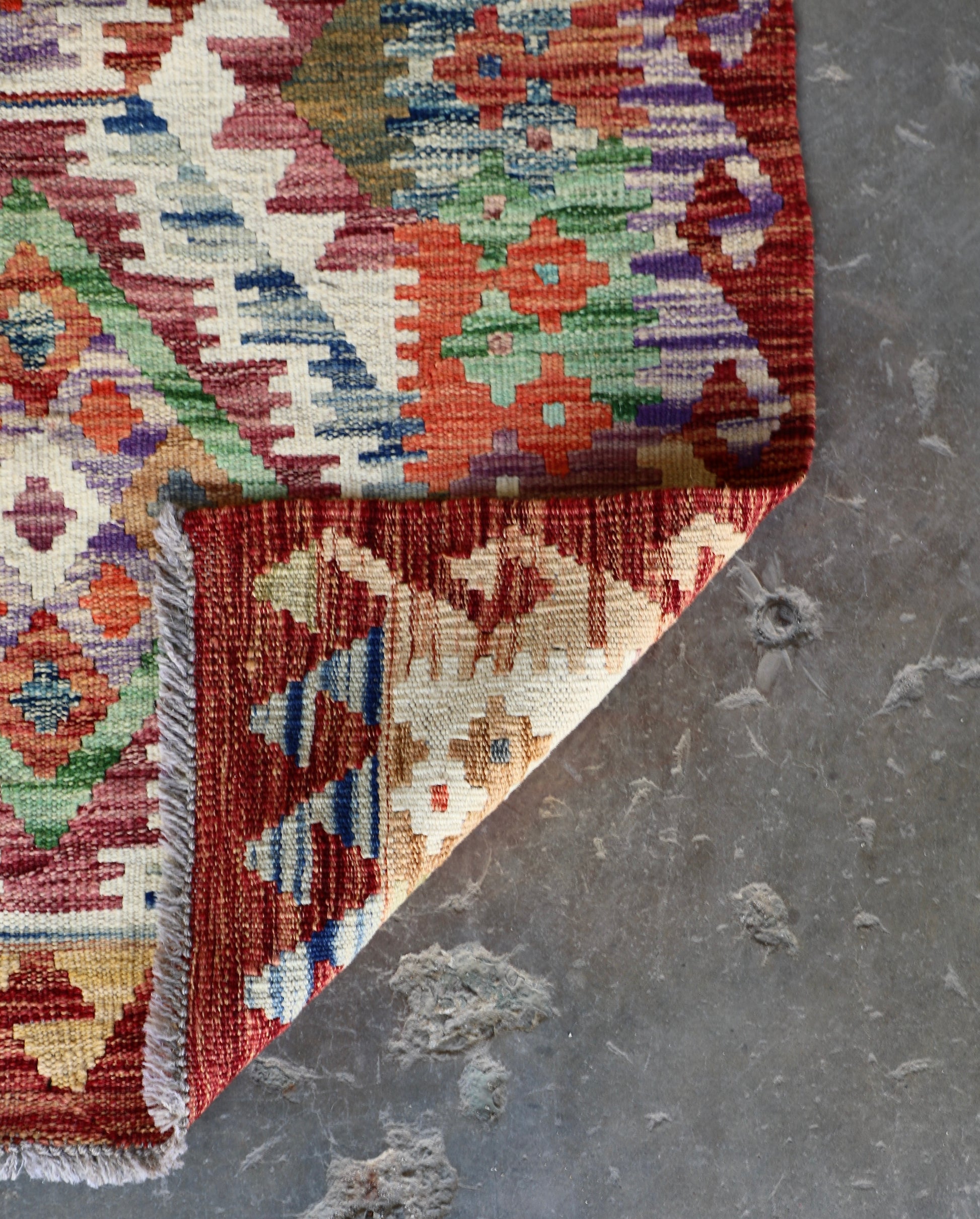 The Afghan Hand Woven Khyber Kilim Runner - 80 X 287. Crafted using traditional vegetable dyed wool, and featuring traditional geometric designs.  Colours, Oranges, reds, yellow, teals and creams. Measures 80 wide X 287 long. Fold.