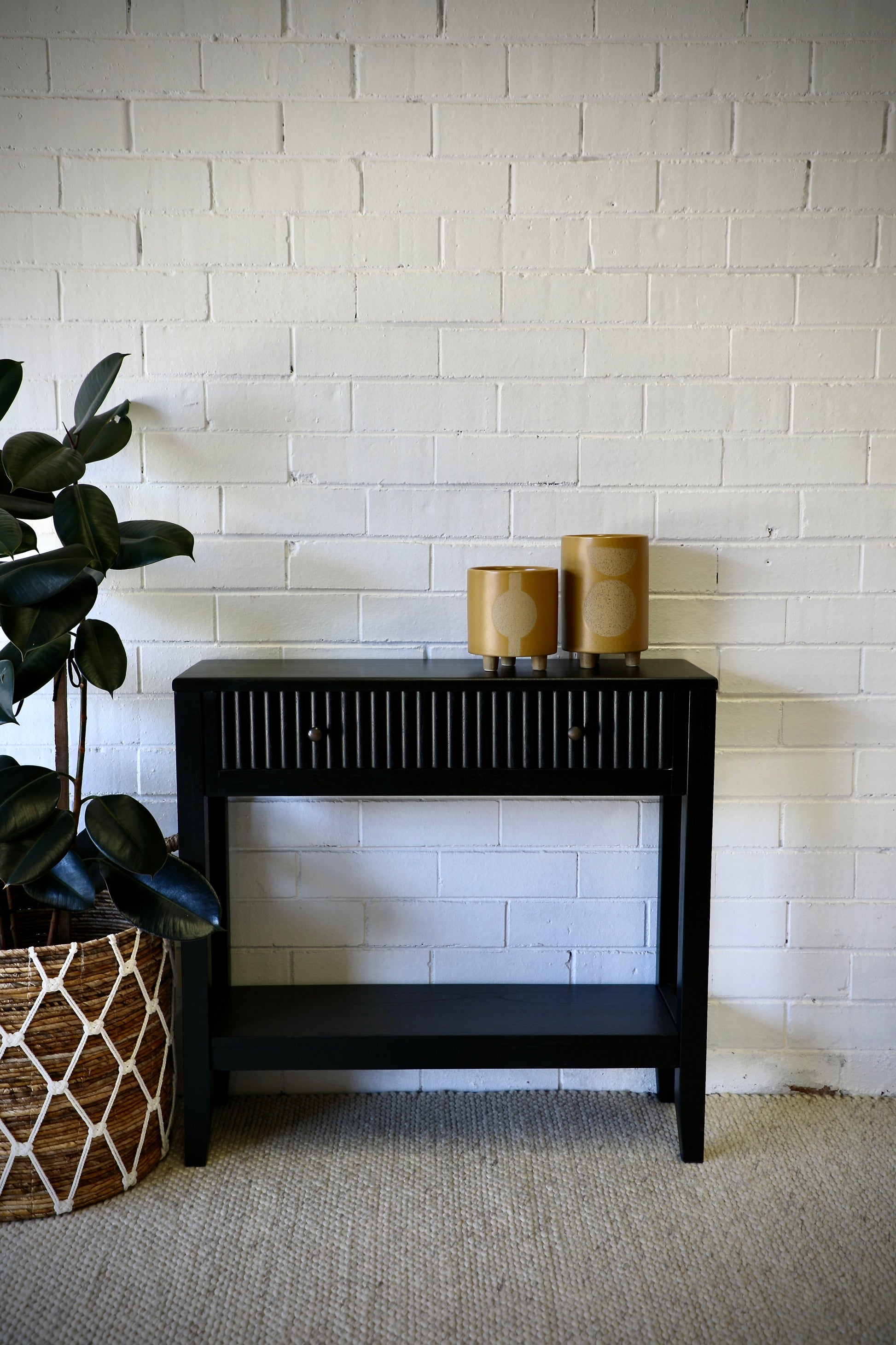 The Vienna - 1 Drawer Black Console, brings a contemporary feel with its sleek design and textured drawer face. Built with sustainable white cedar its 1-drawer sits on wooden runners. Colour black. Measures 800 length X 250 depth X 750 height. Styled.