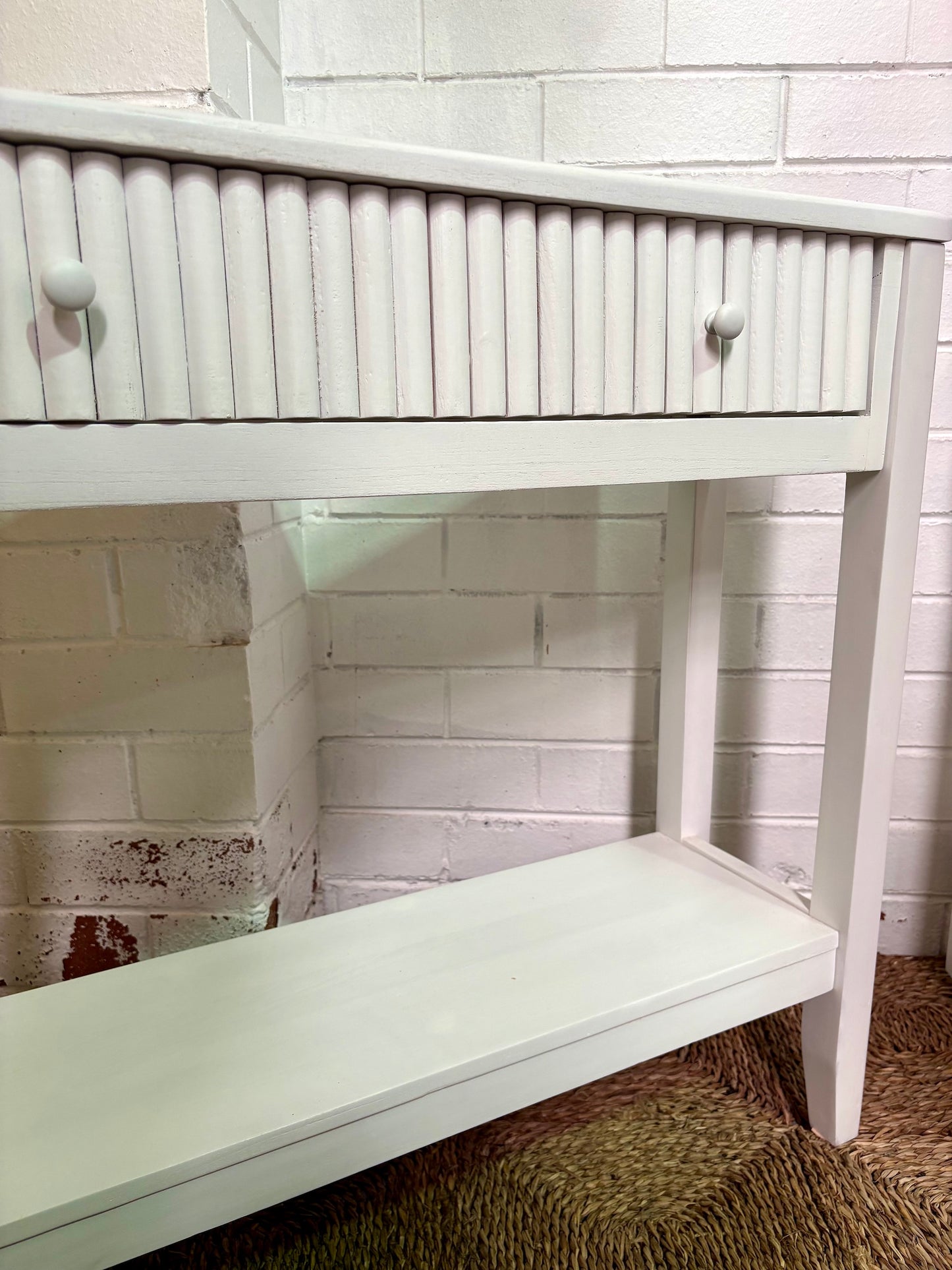 The Vienna - 1 Drawer White Console brings a contemporary feel with its sleek design and textured drawer face. Built with sustainable white cedar its 1-drawer sits on wooden runners. Colour white. Measures 800 length X 250 depth X 750 height. Angle.