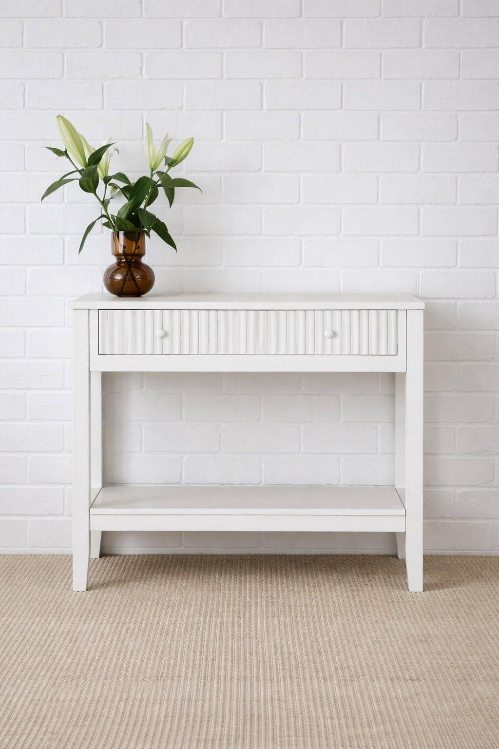 The Vienna - 1 Drawer White Console brings a contemporary feel with its sleek design and textured drawer face. Built with sustainable white cedar its 1-drawer sits on wooden runners. Colour white. Measures 800 length X 250 depth X 750 height. Styled.
