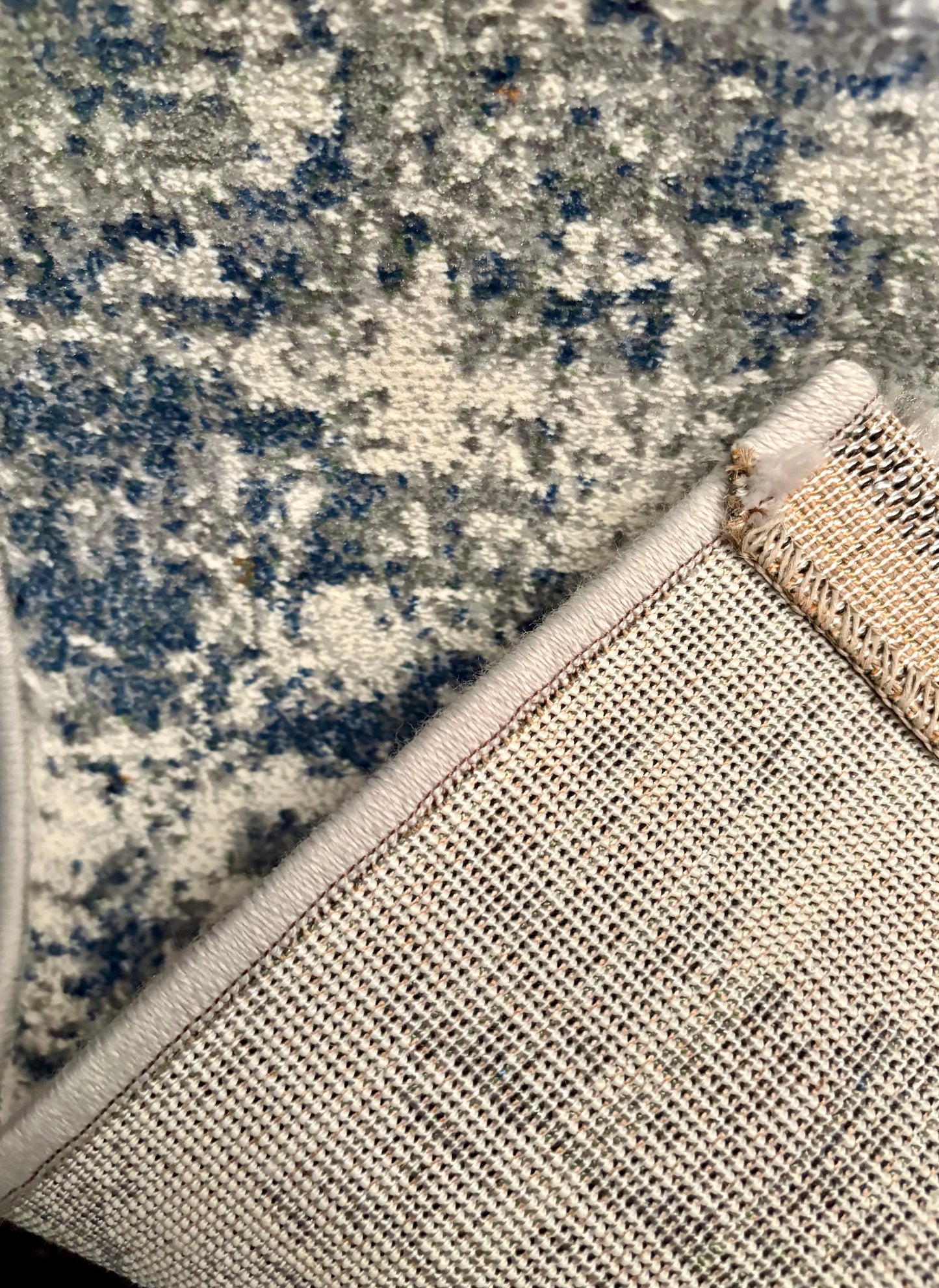 The Zenith Strata rug. This rug is skilfully created from strong heat-set polypropylene, showcasing a stylish contemporary design. Colours, whites, greys, blues, beiges. Fold.